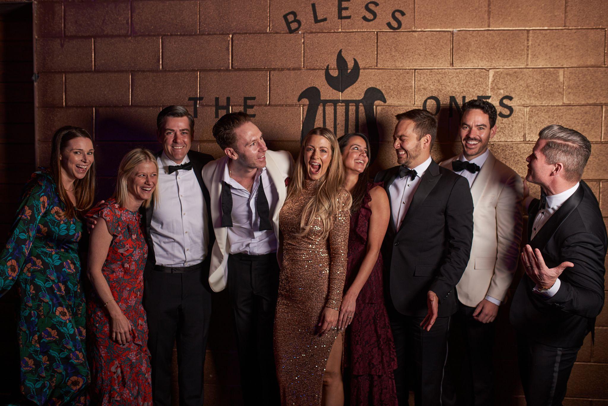 Group in black tie posing against a brick wall at a formal party — Formal Celebrations photography, Austin Formal Celebrations