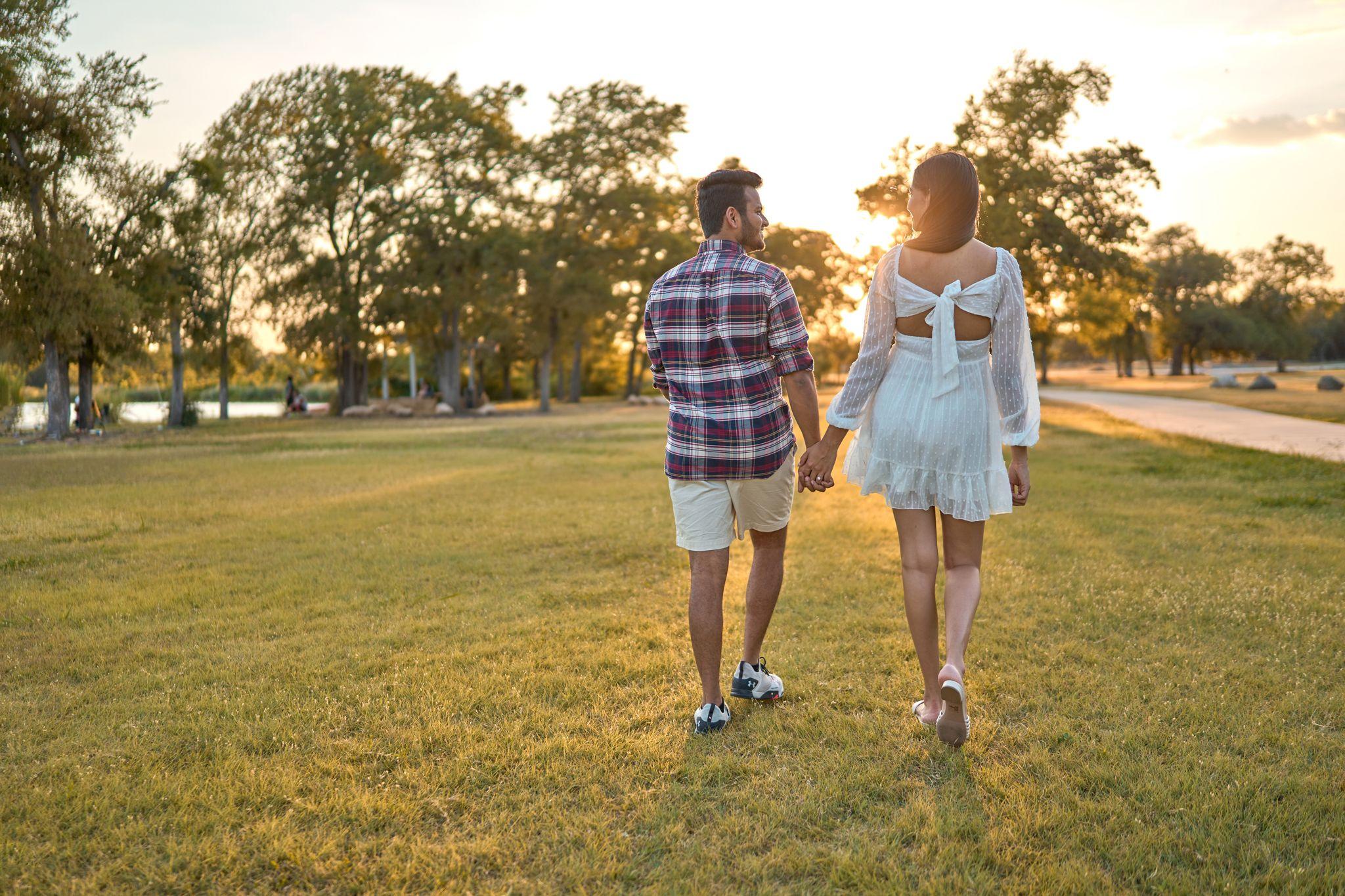 Couple walking away hand in hand across the mown lawn at Brushy Creek Lake Park at sunset — Brushy Creek Lake Park photography, Austin A couple walking away hand in hand across the mown lawn at Brushy Creek Lake Park at sunset