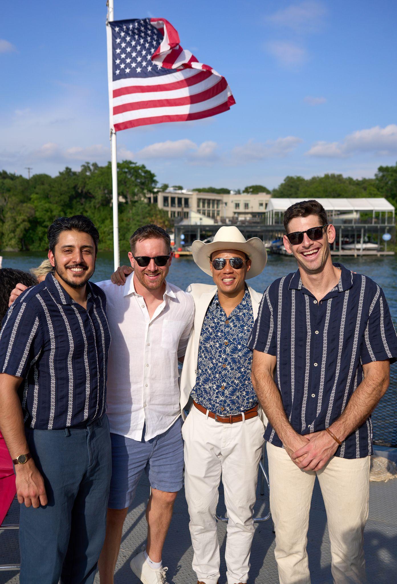 Guests posed on a boat deck beneath a US flag with the lake behind them — Bachelor & Bachelorette photography, Austin Guests posed on a boat deck beneath a US flag with the lake behind them.