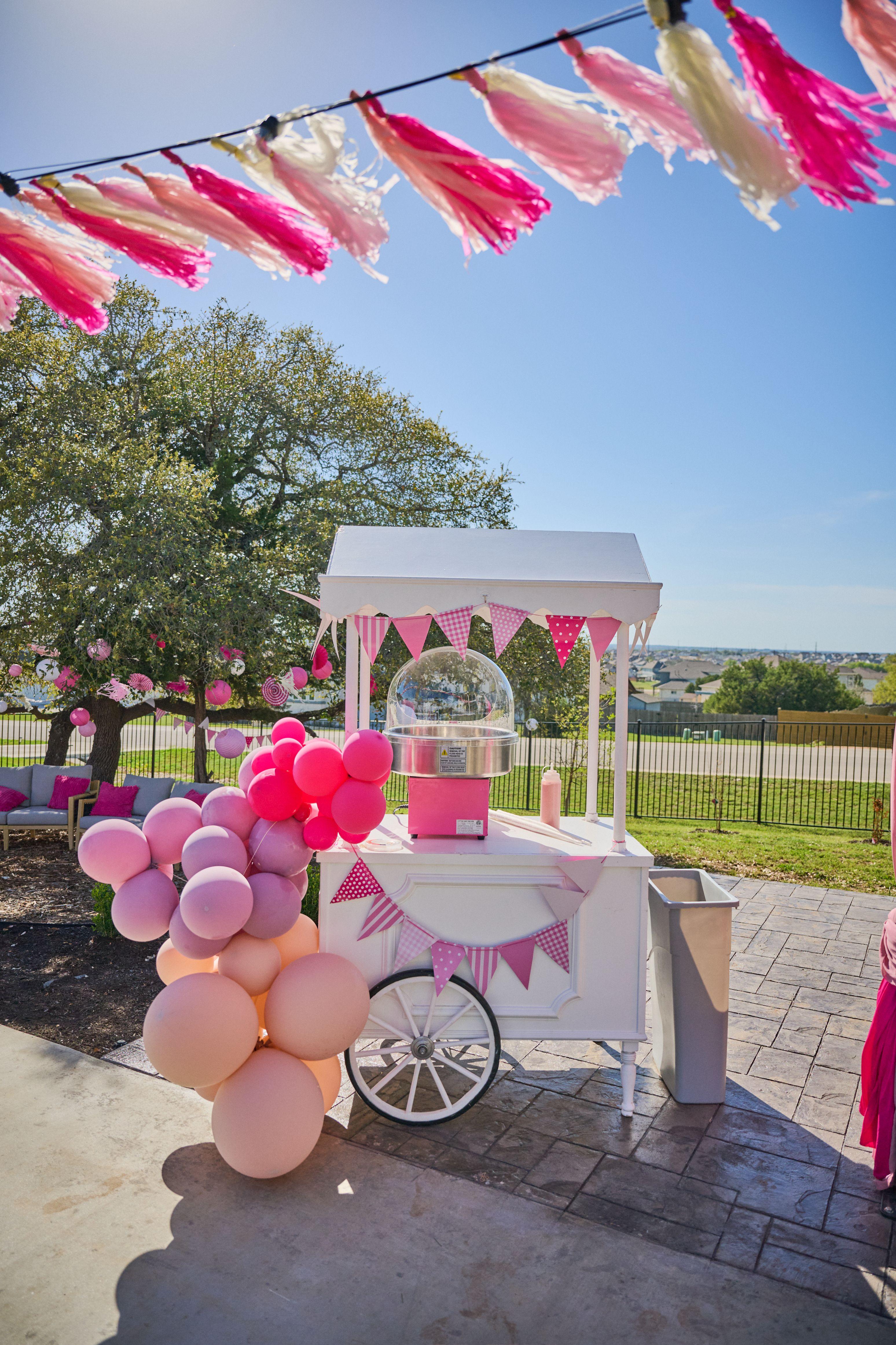 Pink candy cart trimmed with balloons and tassels under an oak at an outdoor party — Family Parties photography, Austin A pink candy cart trimmed with balloons and tassels under an oak at an outdoor party.