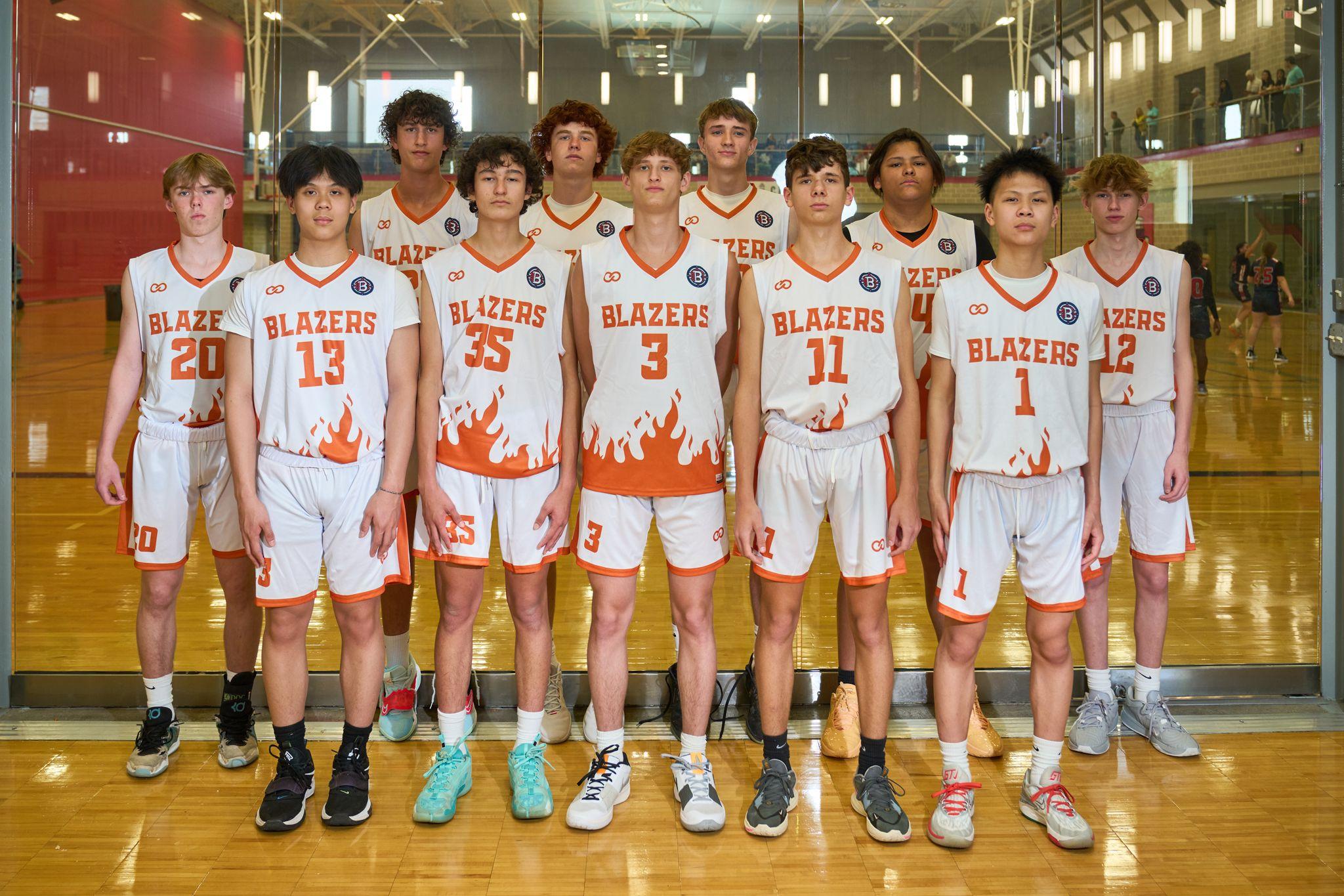 High school basketball team in white and orange Blazers uniforms posed in a row on court — Sports photography, Austin High school basketball team in white and orange Blazers uniforms posed in a row on court