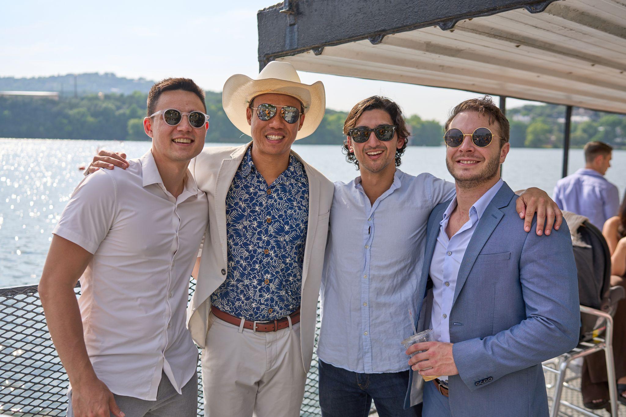Four men in linen shirts and a straw hat posed on the deck of a boat on the lake — Bachelor & Bachelorette photography, Austin Four men in linen shirts and a straw hat posed on the deck of a boat on the lake.