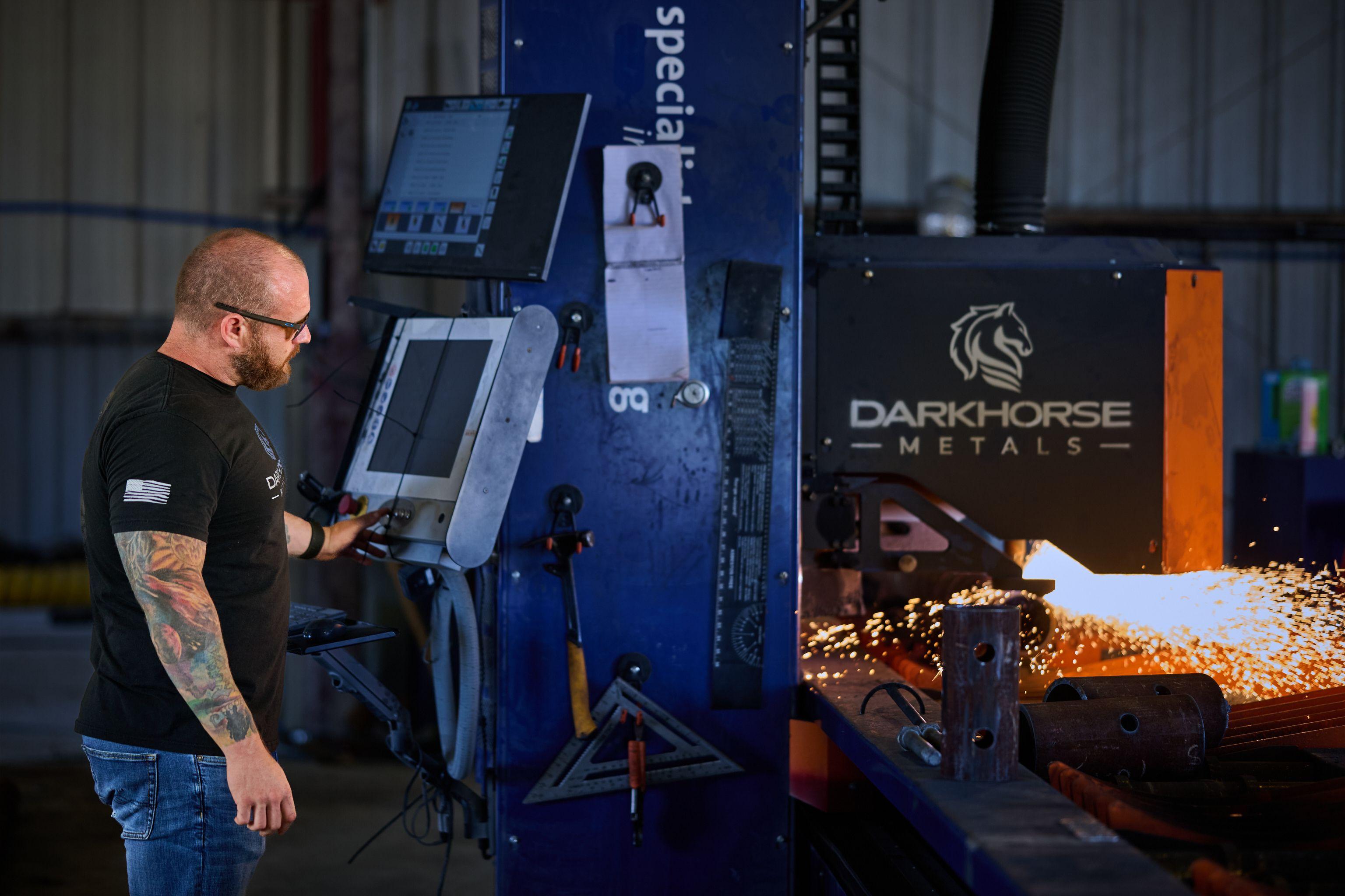Sparks flying inside a blue Darkhorse Metal cutting machine on a fabrication floor — Industrial photography, Austin Sparks flying inside a blue Darkhorse Metal cutting machine on a fabrication floor