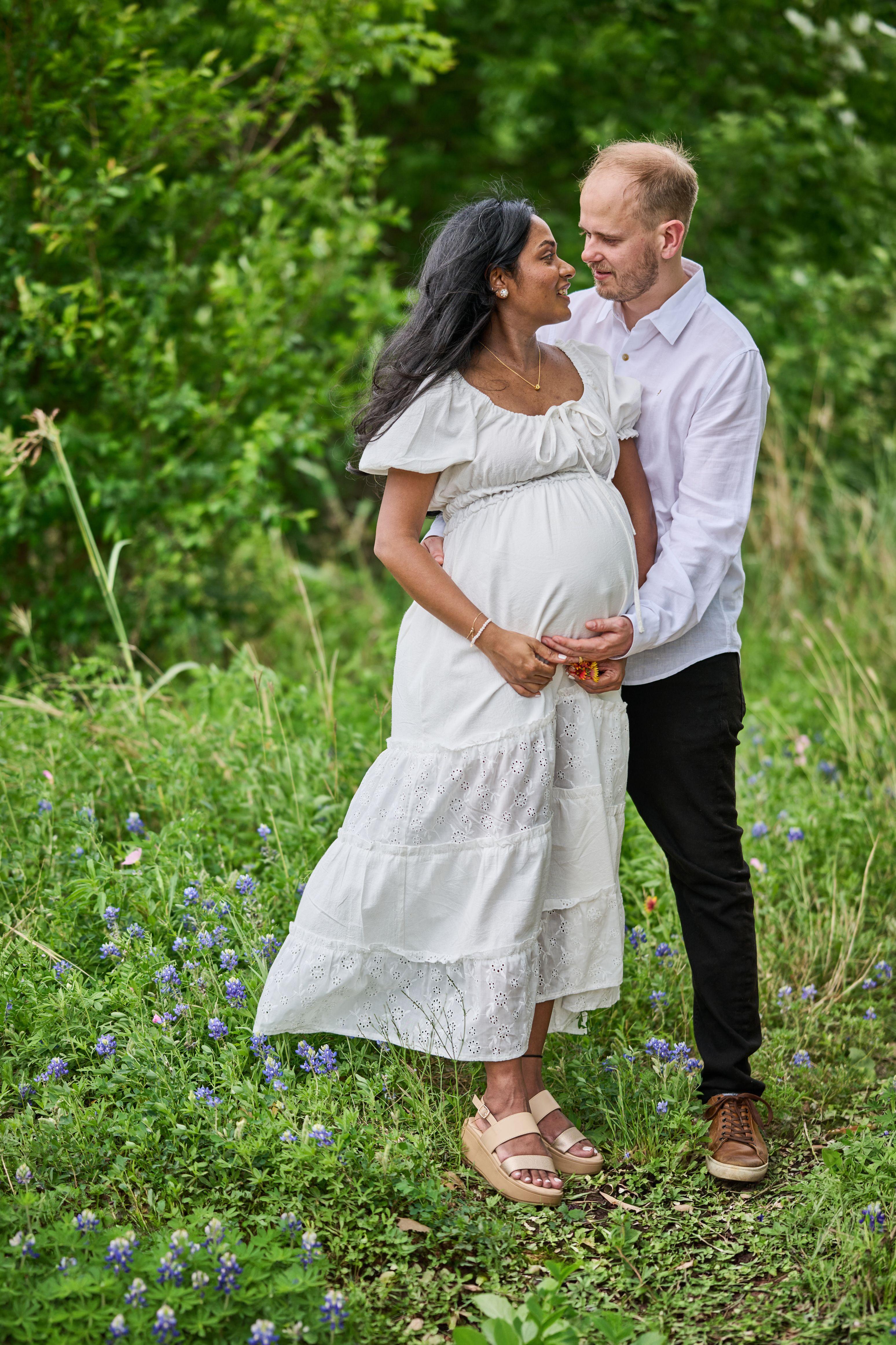 Expectant couple standing together in tall grass and wildflowers — Mueller Lake Park & Butterfly Garden photography, Austin An expectant couple standing together in tall grass and wildflowers at the Mueller butterfly garden