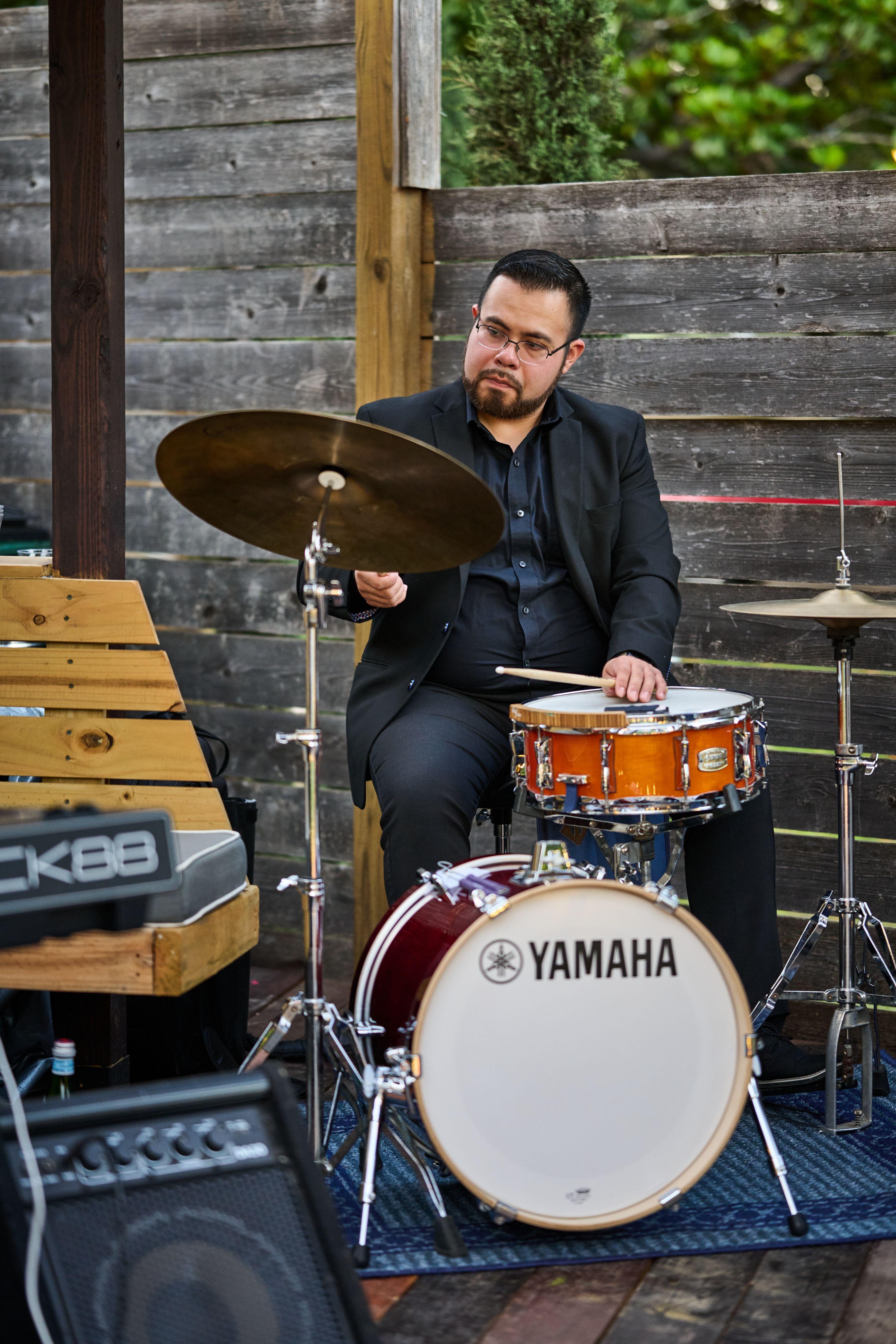 Drummer playing a compact kit on an outdoor stage — Live music photography, Austin A drummer playing a compact kit on an outdoor stage.