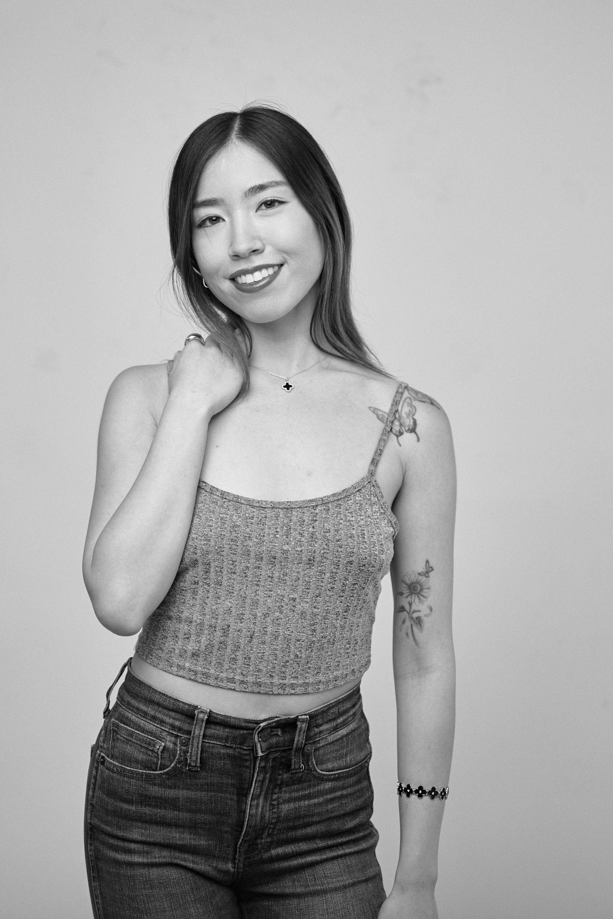 Black and white studio portrait of a model in a knit cami, one hand at her neck — Fashion & editorial photography, Austin A black and white studio portrait of a model in a knit cami, one hand at her neck.
