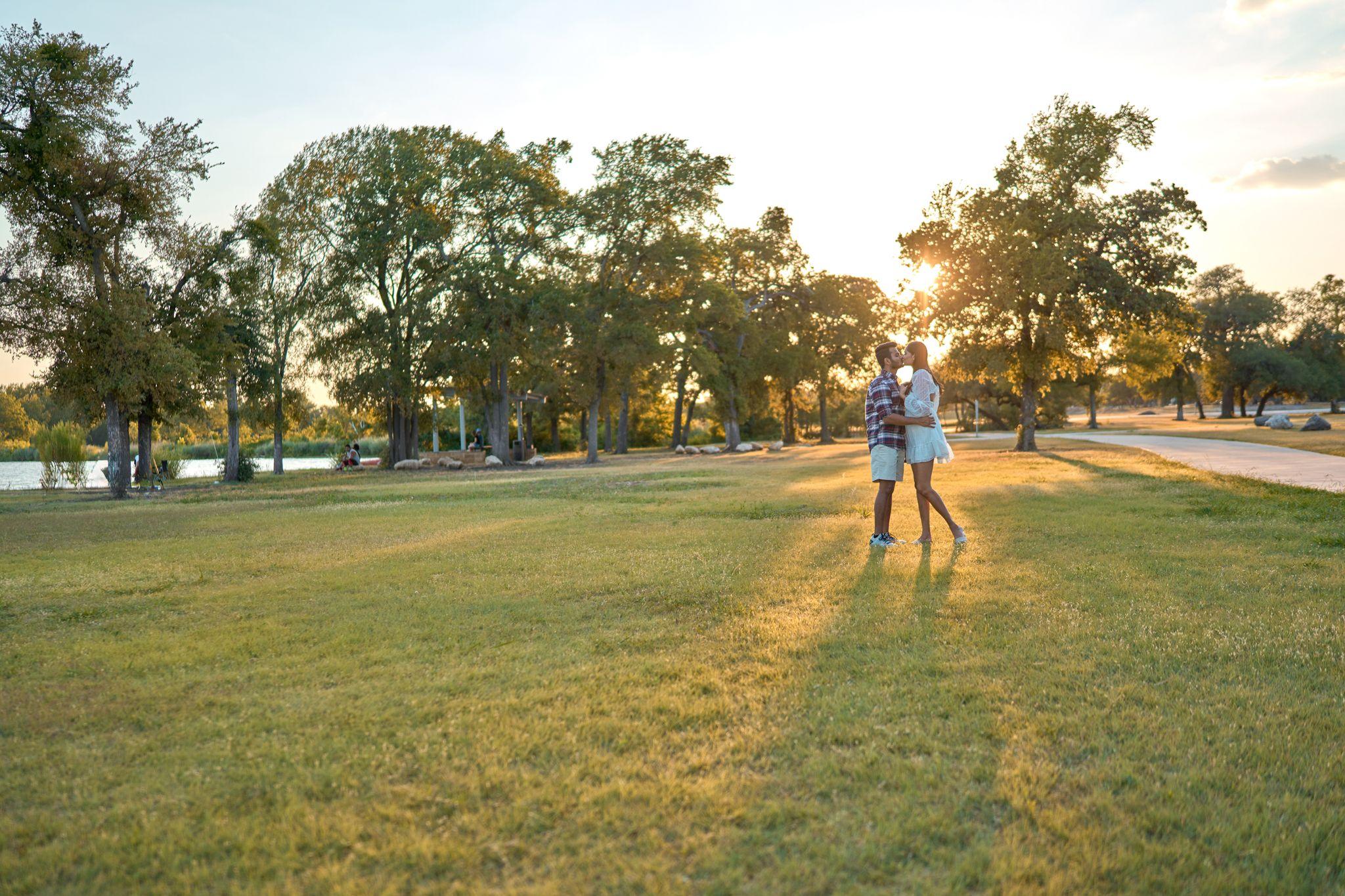 Couple standing small in the wide sunset meadow at Brushy Creek Lake Park with the treeline — Brushy Creek Lake Park photography, Austin A couple standing small in the wide sunset meadow at Brushy Creek Lake Park with the treeline behind them