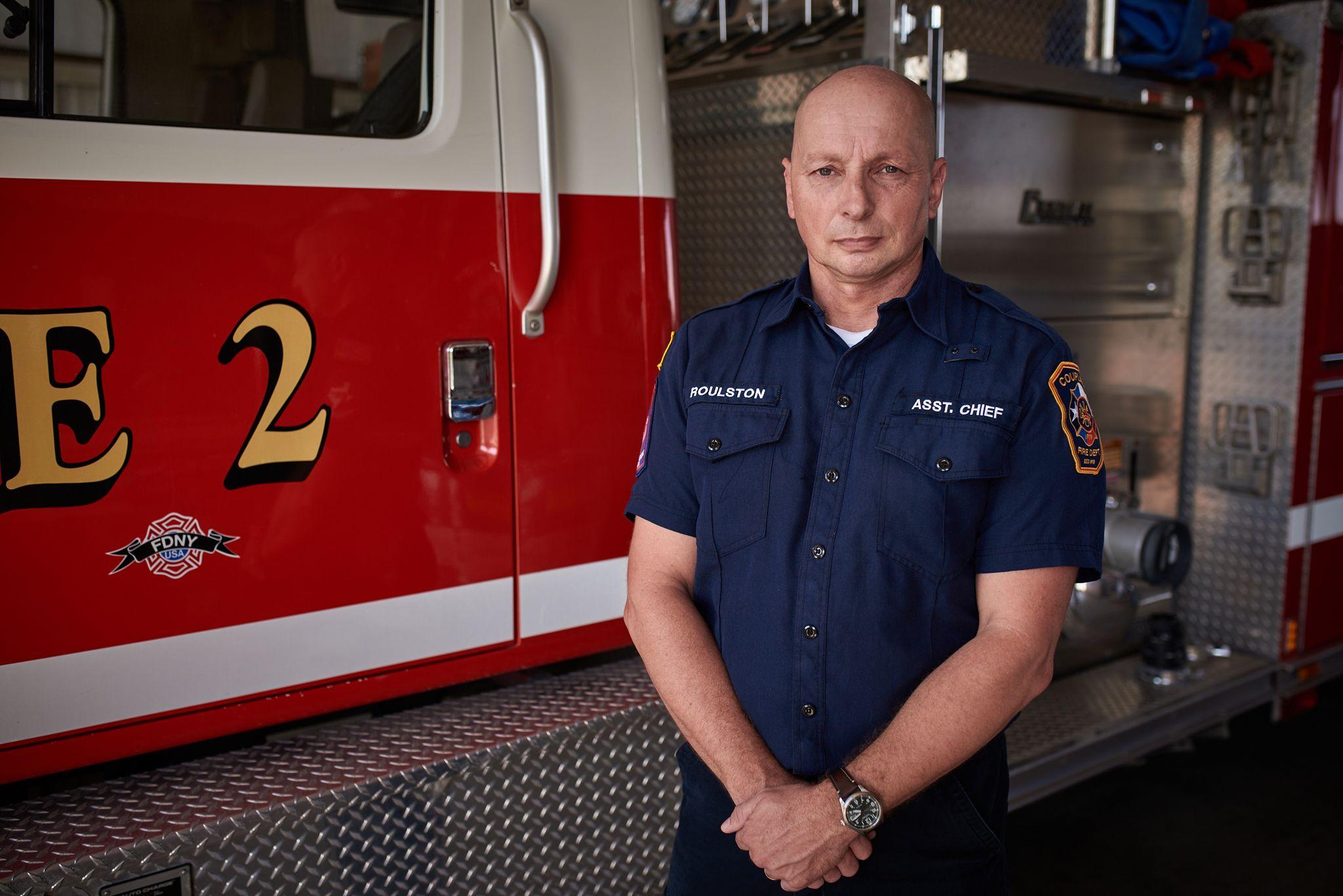 Assistant fire chief standing in front of a fire truck — Portrait photography, Austin An assistant fire chief standing in front of a fire truck.