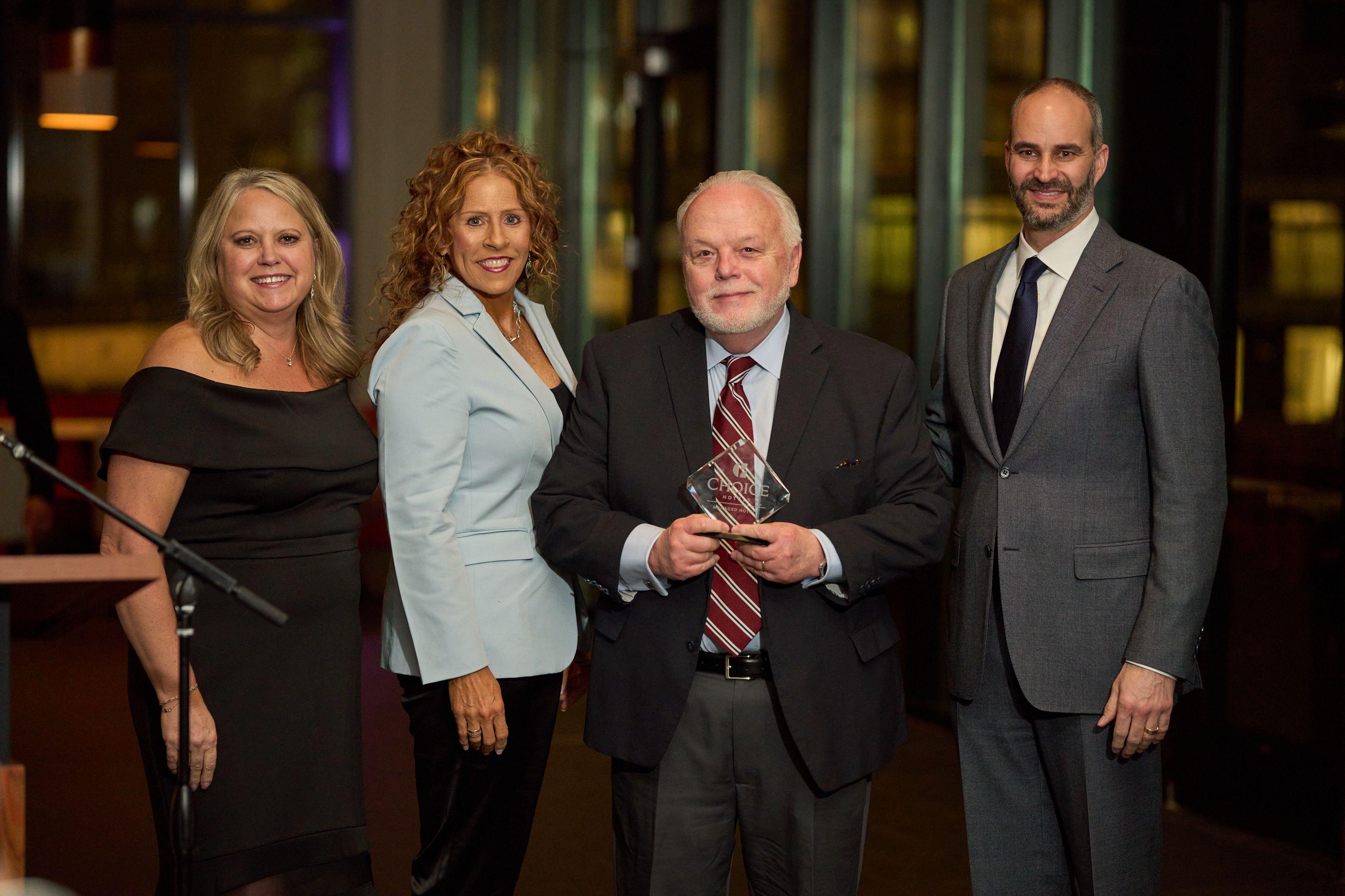 Two award recipients holding a glass trophy together for a portrait at a formal reception — Business Parties photography, Austin Two award recipients holding a glass trophy together for a portrait at a formal reception.