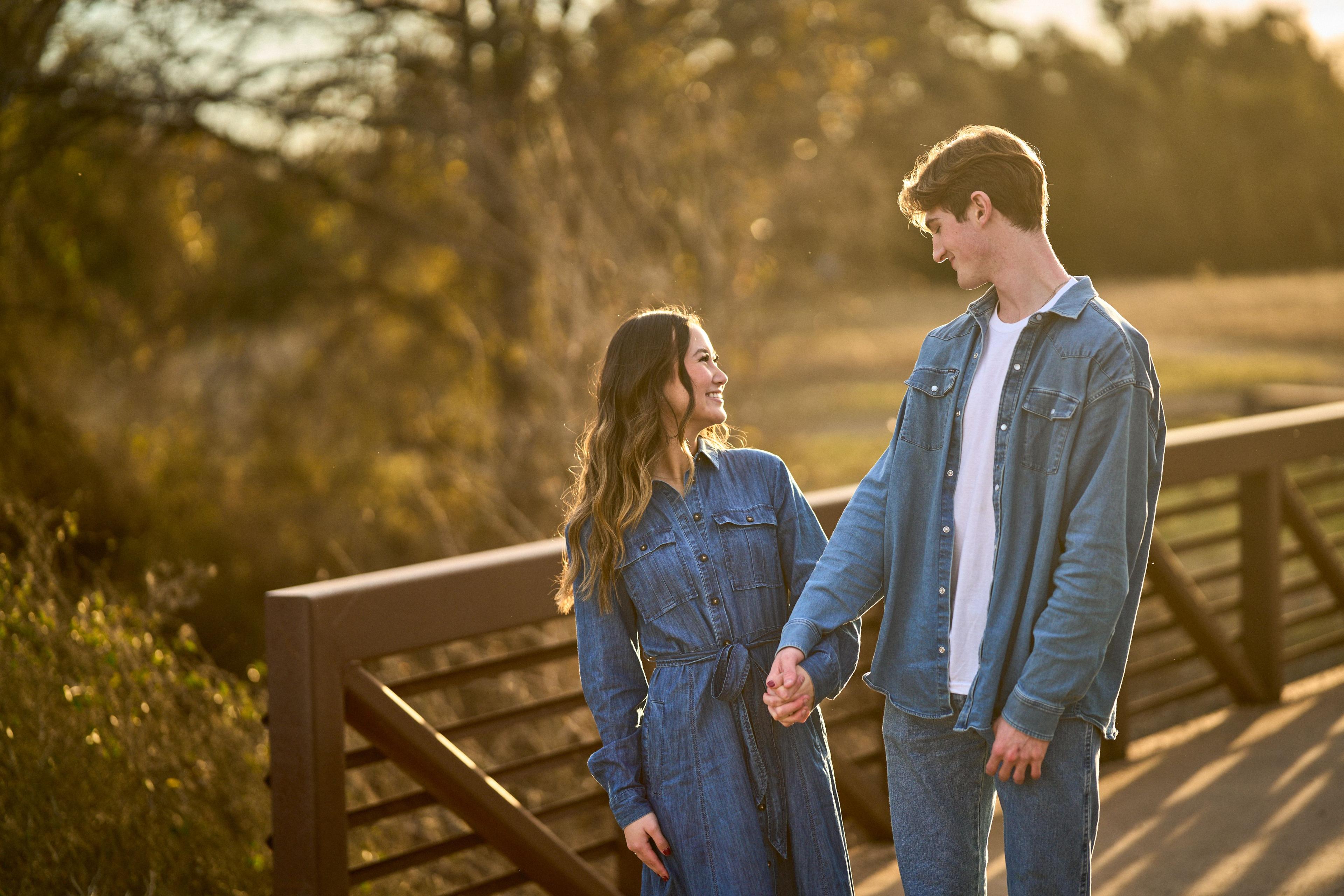 A couple in denim walking hand in hand along the boardwalk bridge at Brushy Creek Lake Park