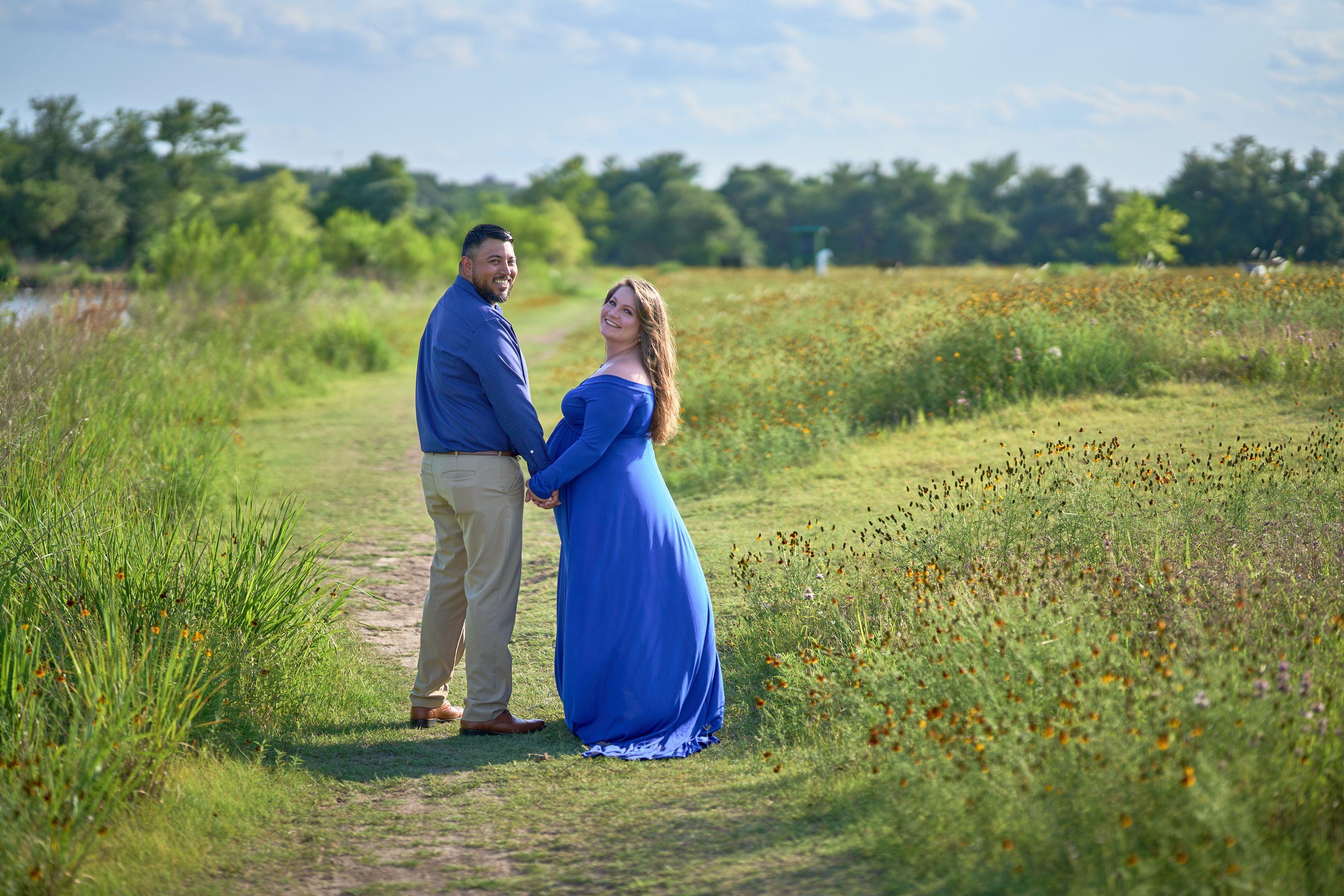 Couple in navy and blue holding hands on a path through a wildflower meadow — Seasonal Wildflower Season in Texas photography, Austin A couple in navy and blue holding hands on a path through a wildflower meadow.