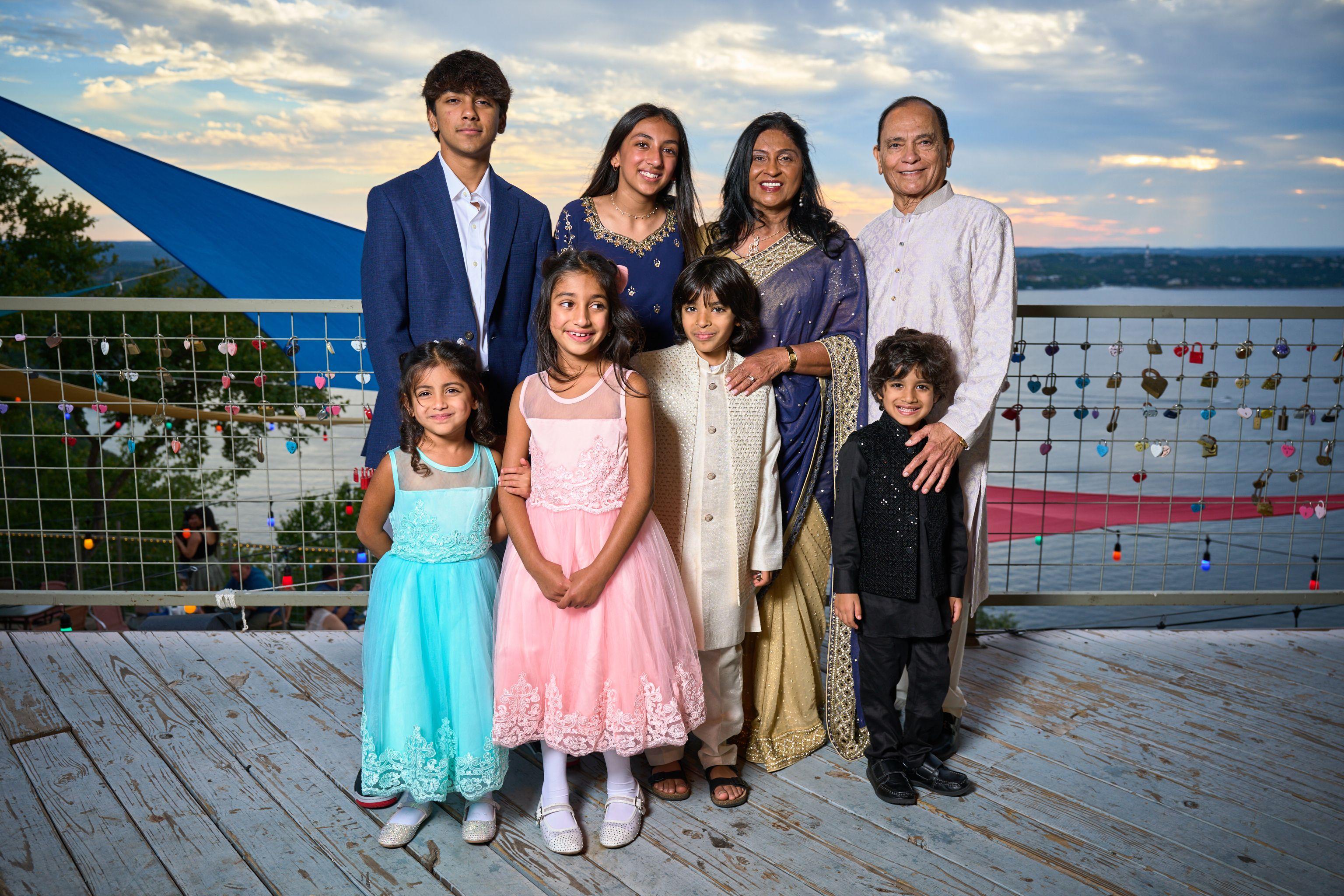 Multi-generational family in formal Indian dress on an outdoor deck at sunset, a lake — Formal Celebrations photography, Austin A multi-generational family in formal Indian dress on an outdoor deck at sunset, a lake and a fence hung with love locks behind them