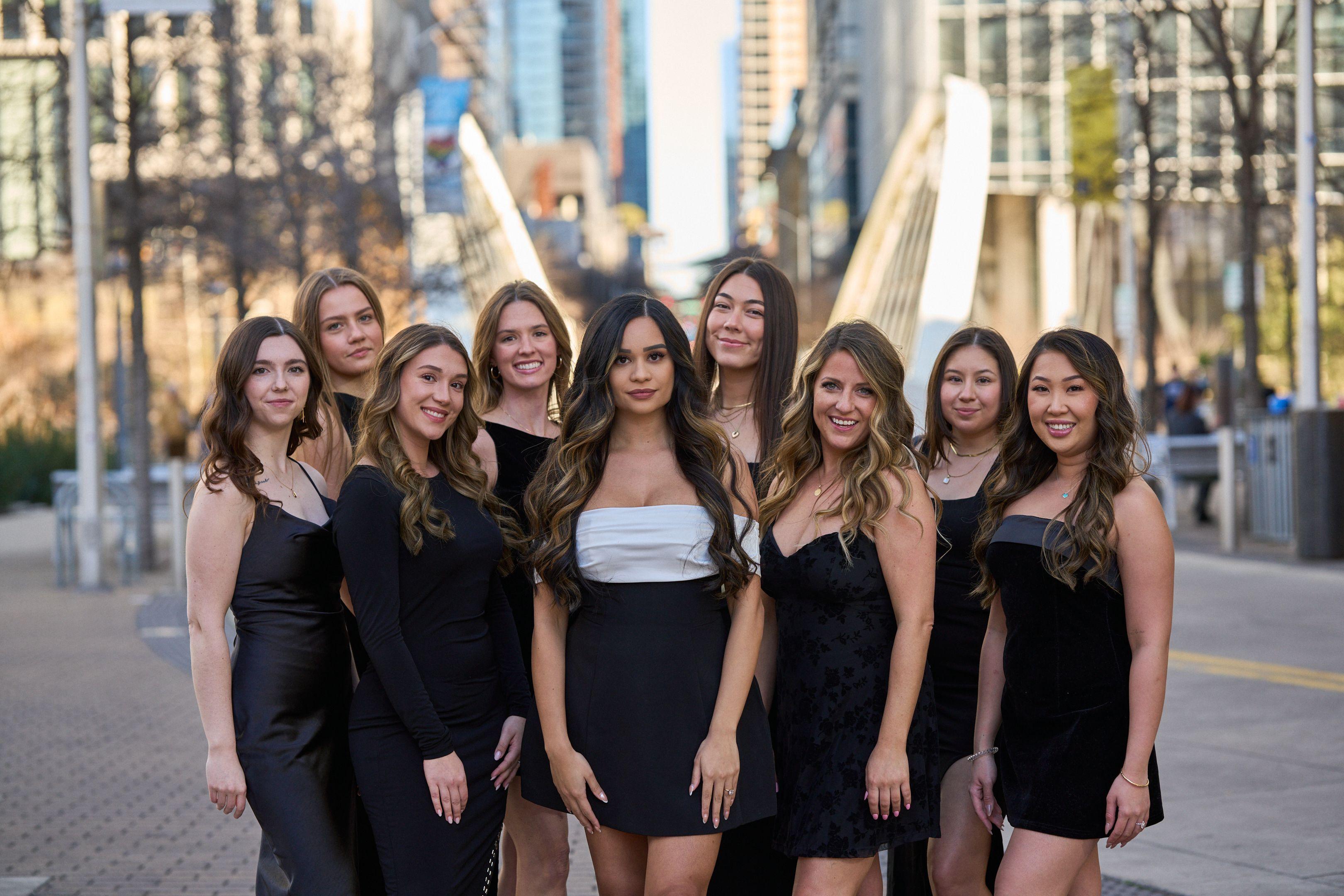 Group in black and white dresses posed together with the Austin skyline — Bachelor & Bachelorette photography, Austin A group in black and white dresses posed together with the Austin skyline behind.