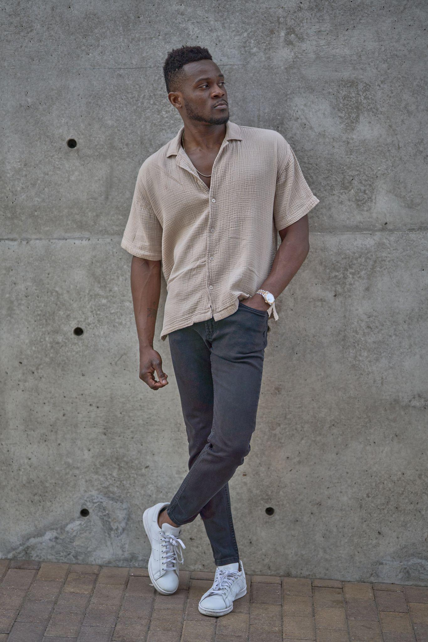 Man in a cream shirt leaning against a warm concrete wall in downtown Austin — Downtown Austin photography, Austin A man in a cream shirt leaning against a warm concrete wall in downtown Austin.