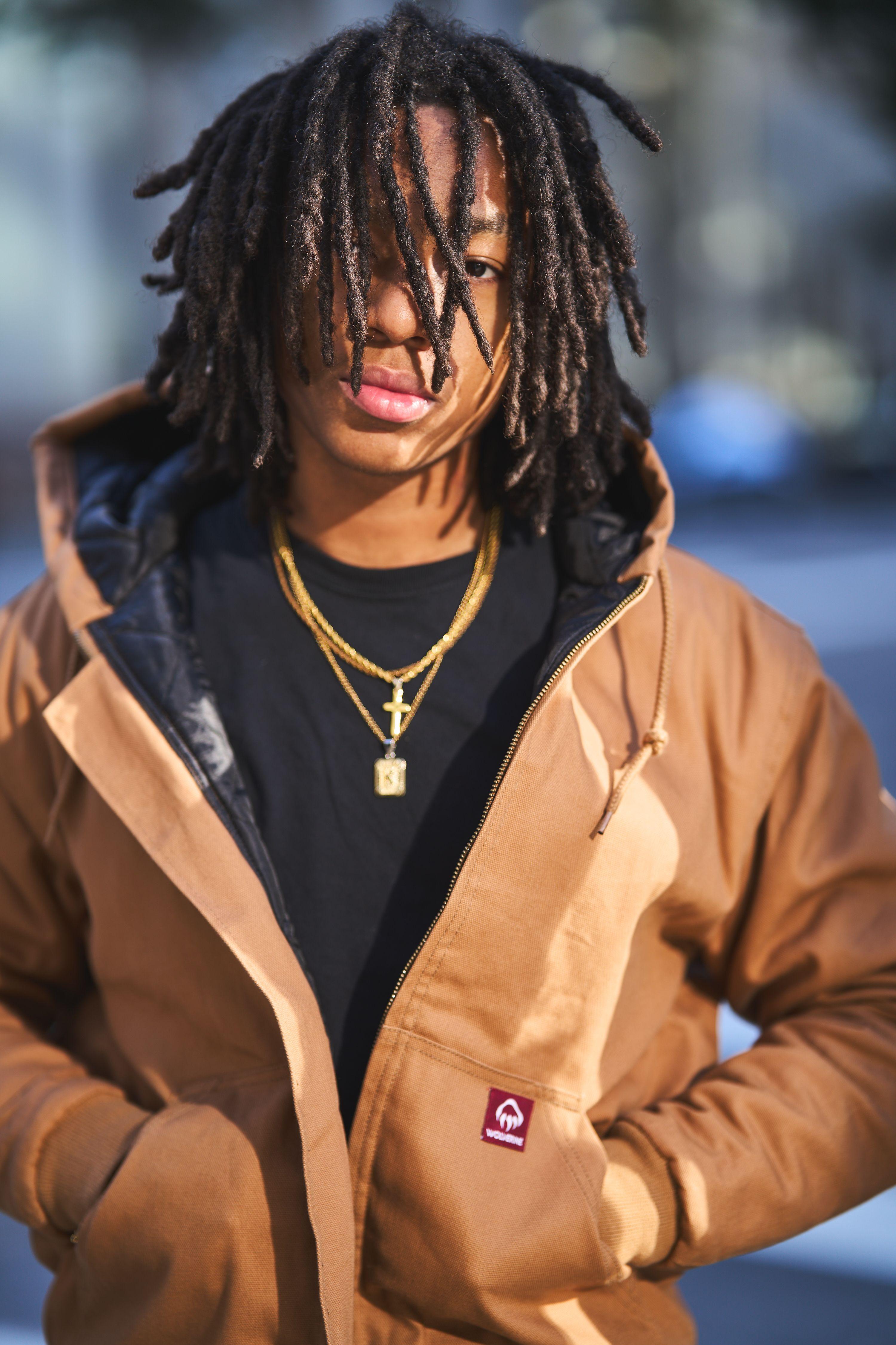 Young man in a tan work jacket and gold chain photographed on a street — Portrait photography, Austin A young man in a tan work jacket and gold chain photographed on a street.
