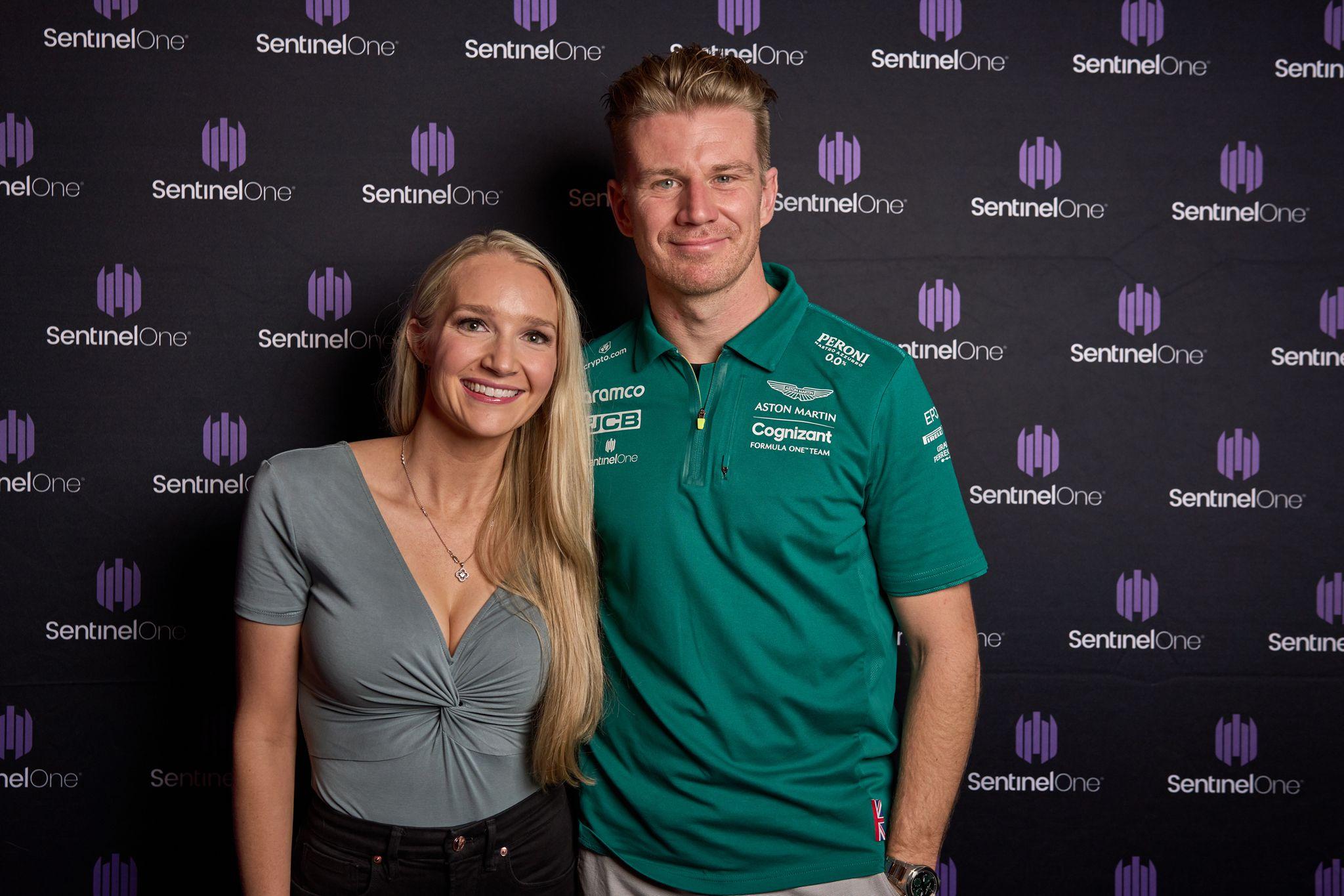 Guest photographed with an Aston Martin Formula 1 driver on the SentinelOne sponsor wall — Brand Collaborations photography, Austin A guest photographed with an Aston Martin Formula 1 driver on the SentinelOne sponsor wall.