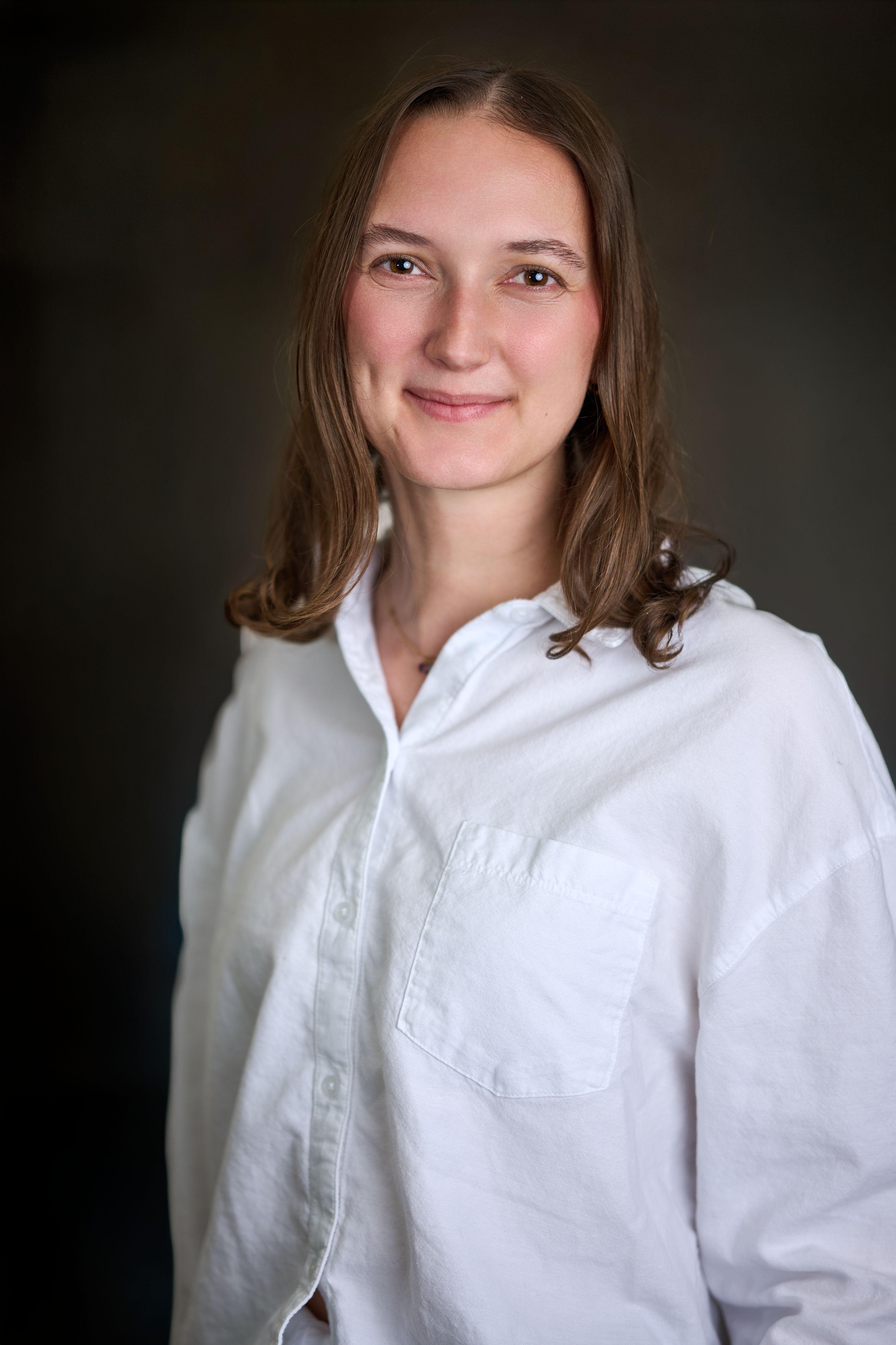 Young woman in a white shirt photographed against a plain light studio background — Commercial photo studio, Austin Young woman in a white shirt photographed against a plain light studio background