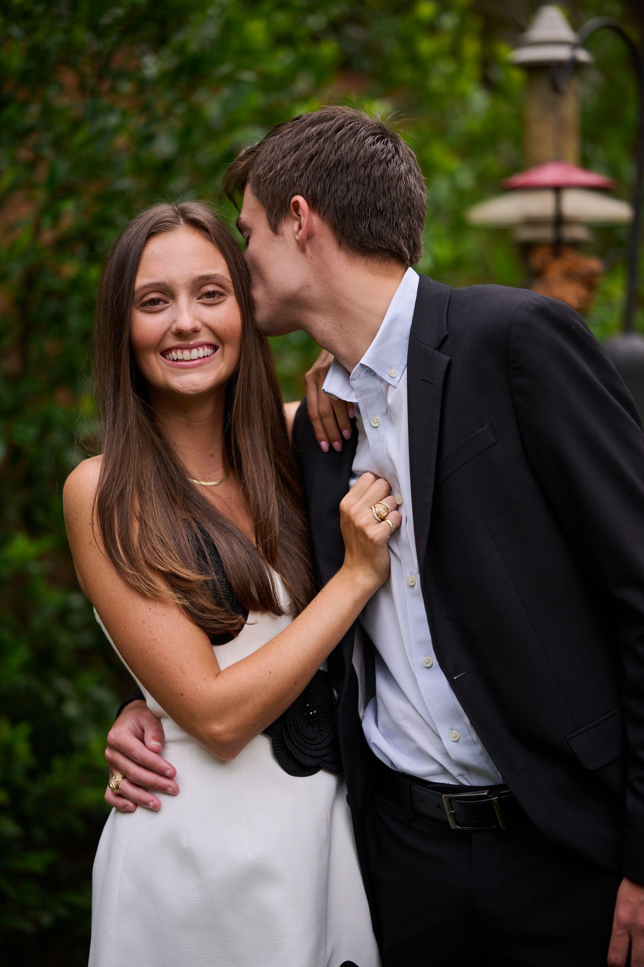Young couple in black tie embracing, she laughing as he kisses her cheek — Formal Celebrations photography, Austin A young couple in black tie embracing, she laughing as he kisses her cheek.