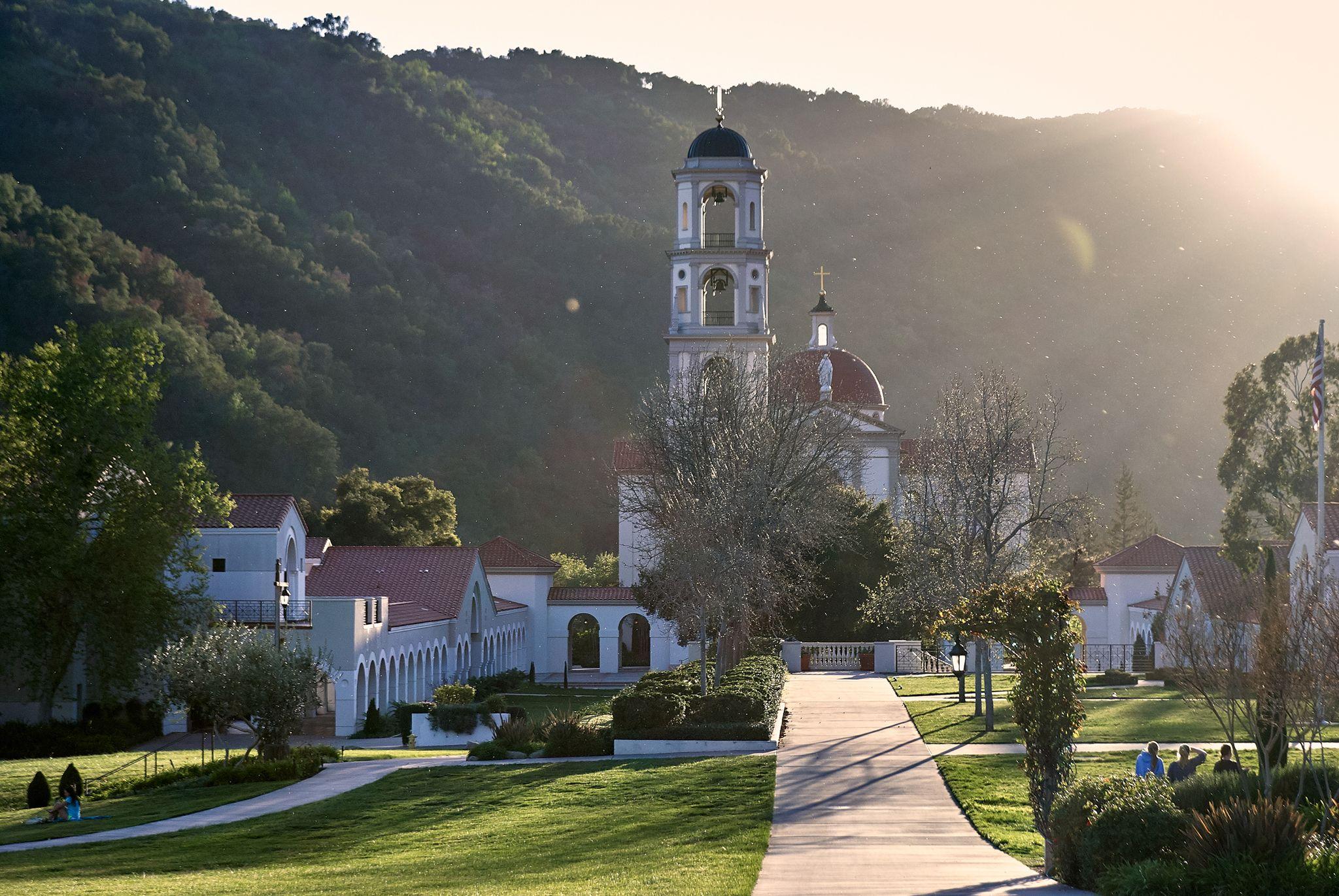 Hilltop church with a white bell tower and dome, seen along its drive at golden hour — Religious Ceremonies photography, Austin A hilltop church with a white bell tower and dome, seen along its drive at golden hour.