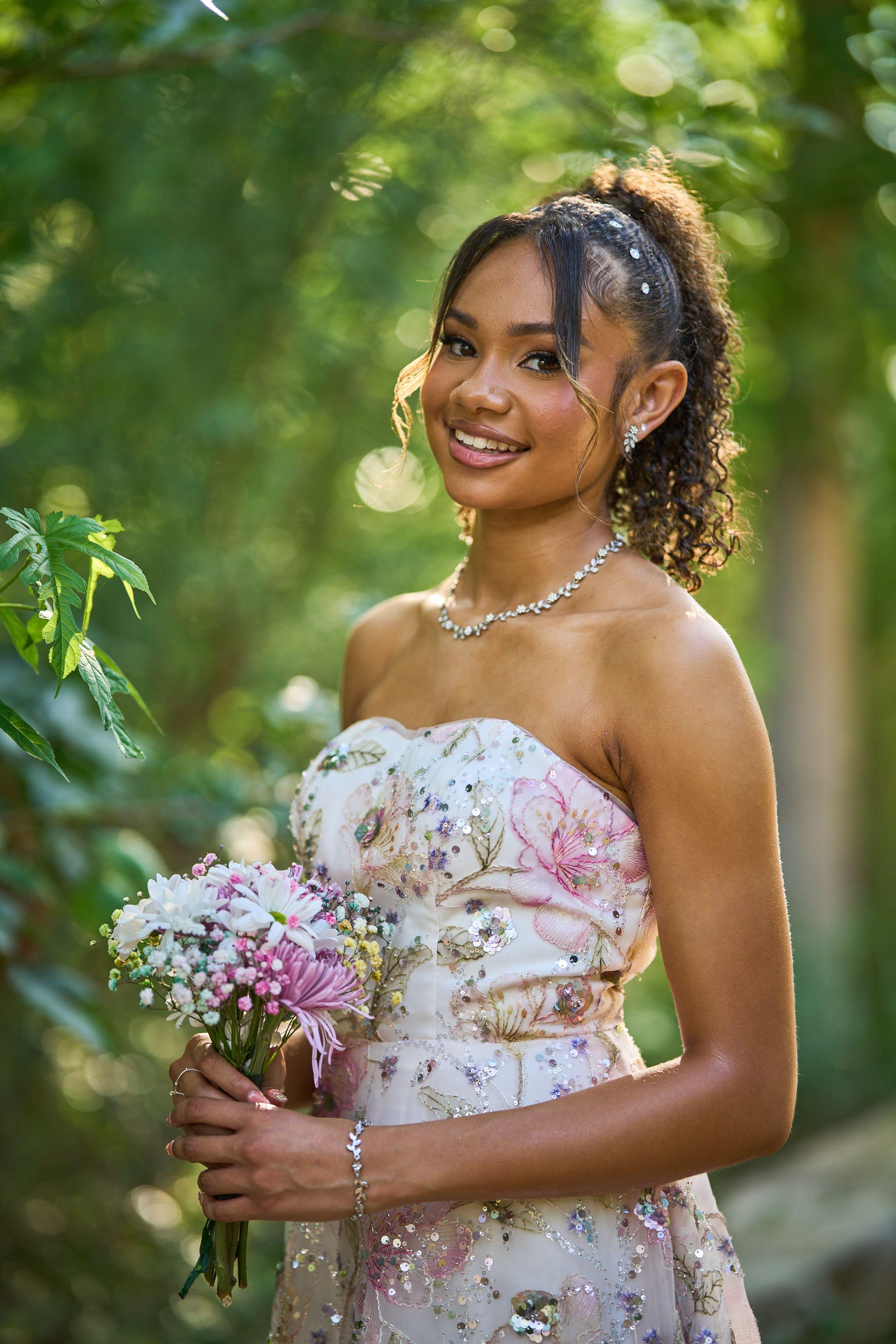 Prom-goer in a floral gown holding a small bouquet of pink flowers — Butler Metro Park photography, Austin A prom-goer in a floral gown holding a small bouquet of pink flowers.