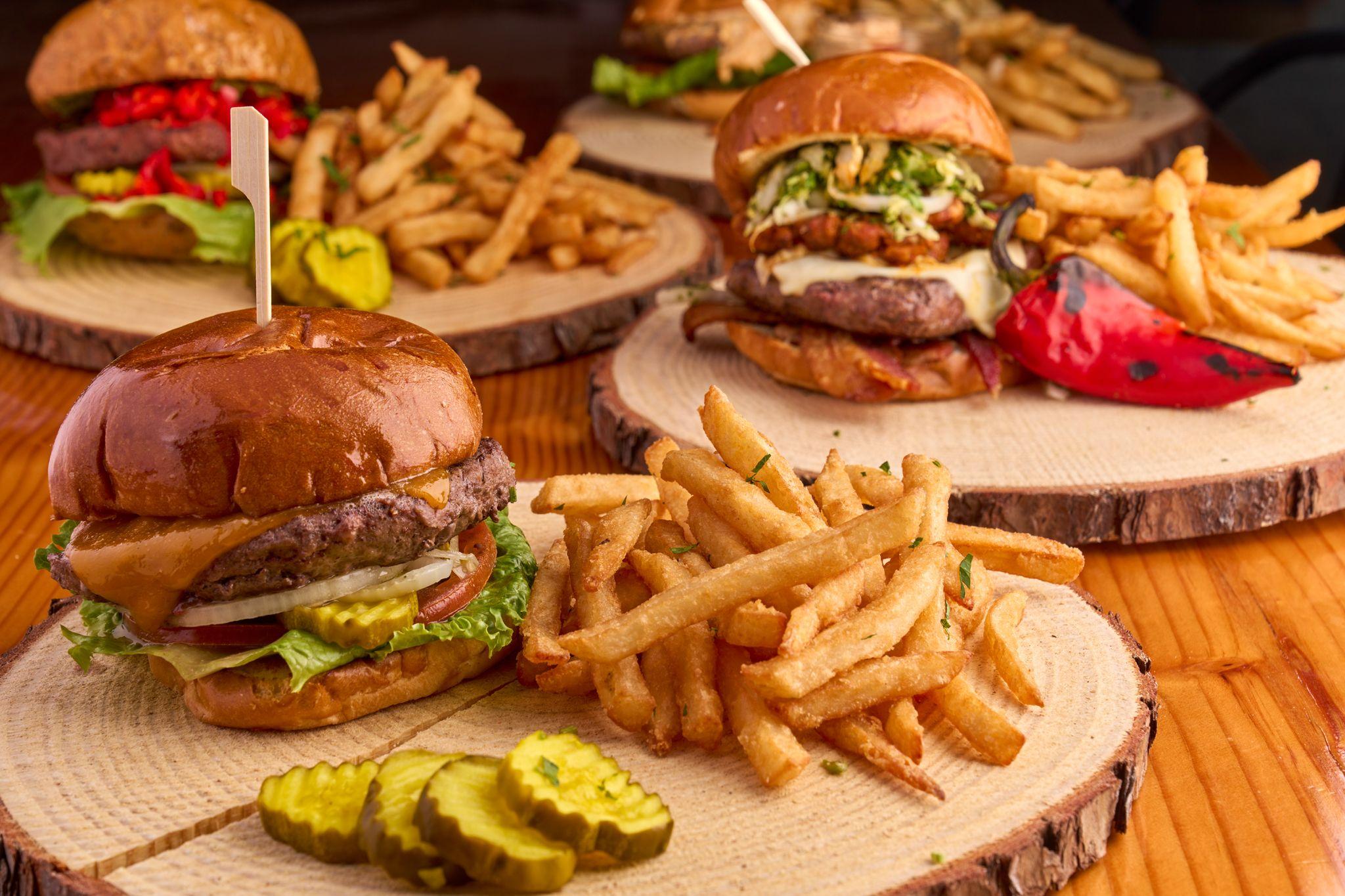 Burgers and fries served on wooden boards with pickles — Food & restaurant photography, Austin Burgers and fries served on wooden boards with pickles.