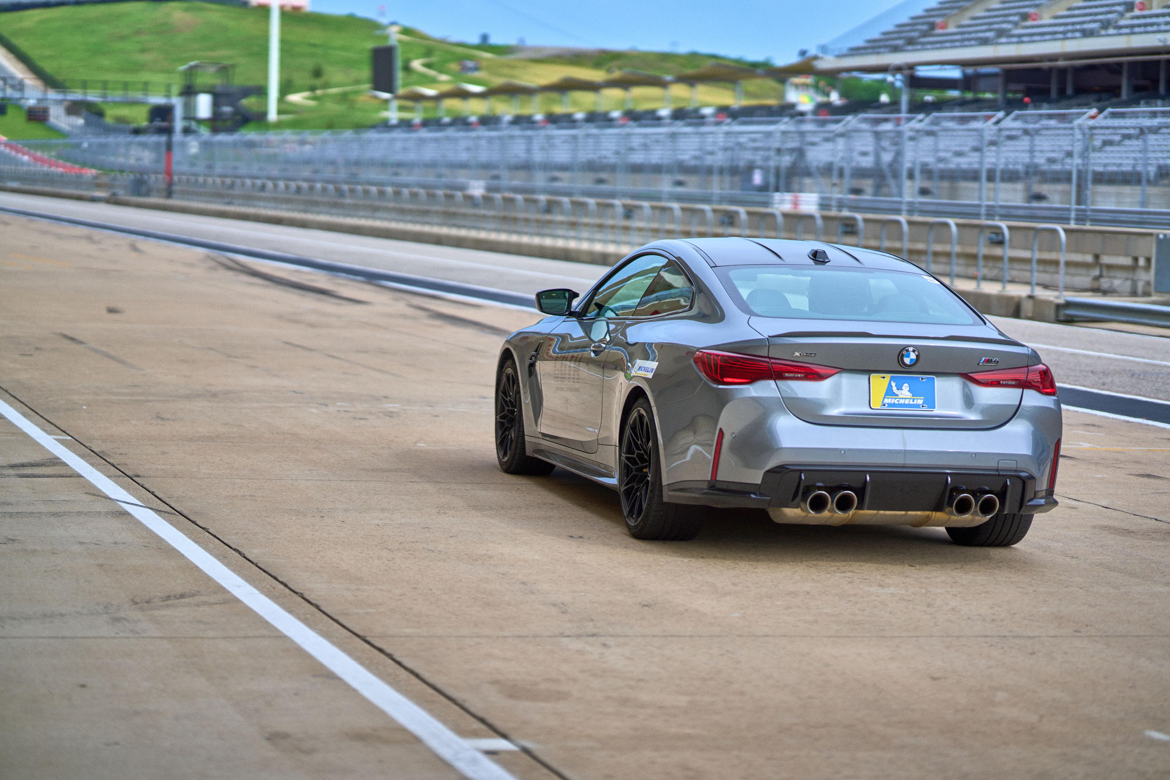 Gray BMW M4 driving on a race circuit — Brand activation photography, Austin A gray BMW M4 driving on a race circuit.