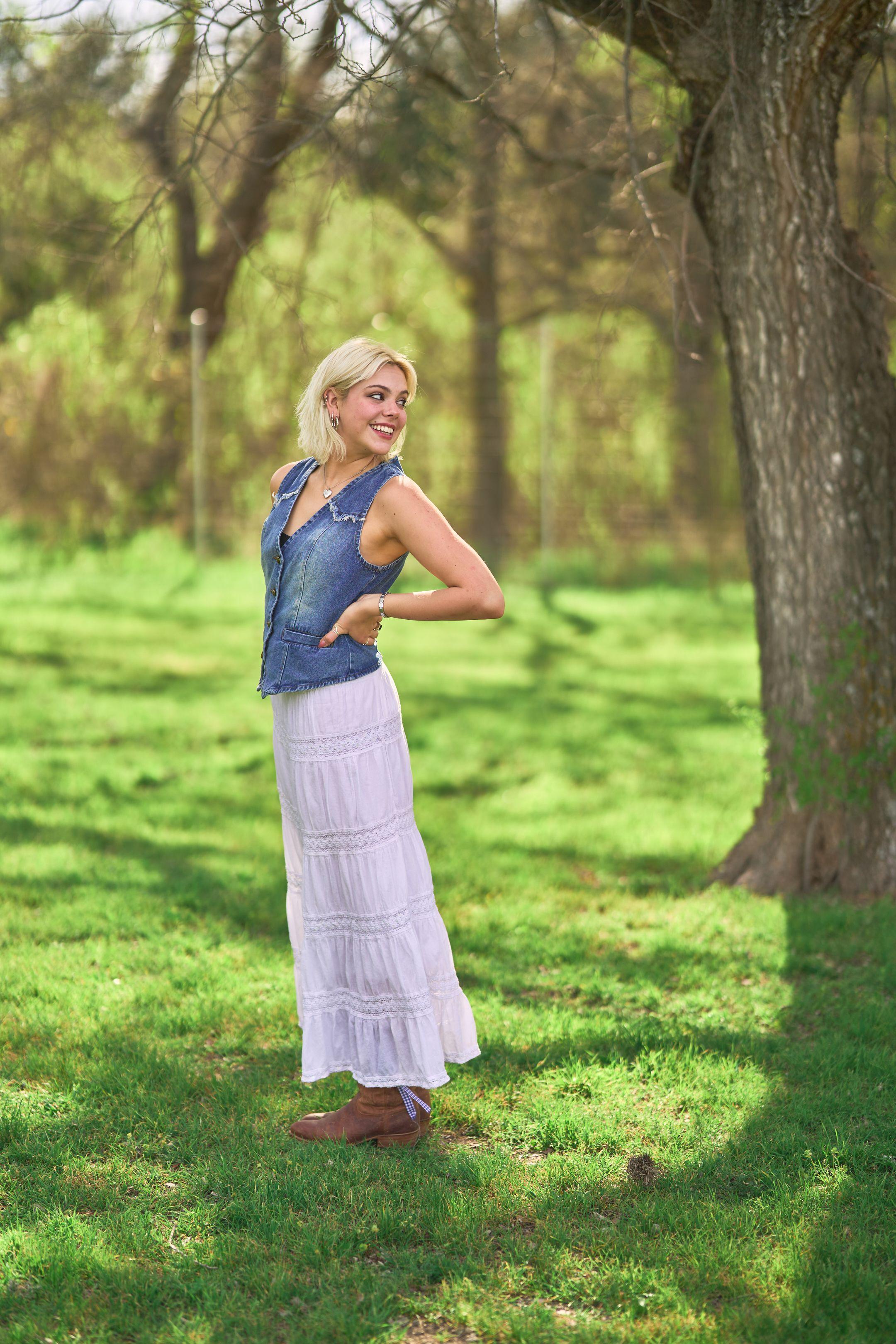 Young woman in a denim waistcoat standing among the oaks at Commons Ford Ranch — Commons Ford Ranch photography, Austin A young woman in a denim waistcoat standing among the oaks at Commons Ford Ranch