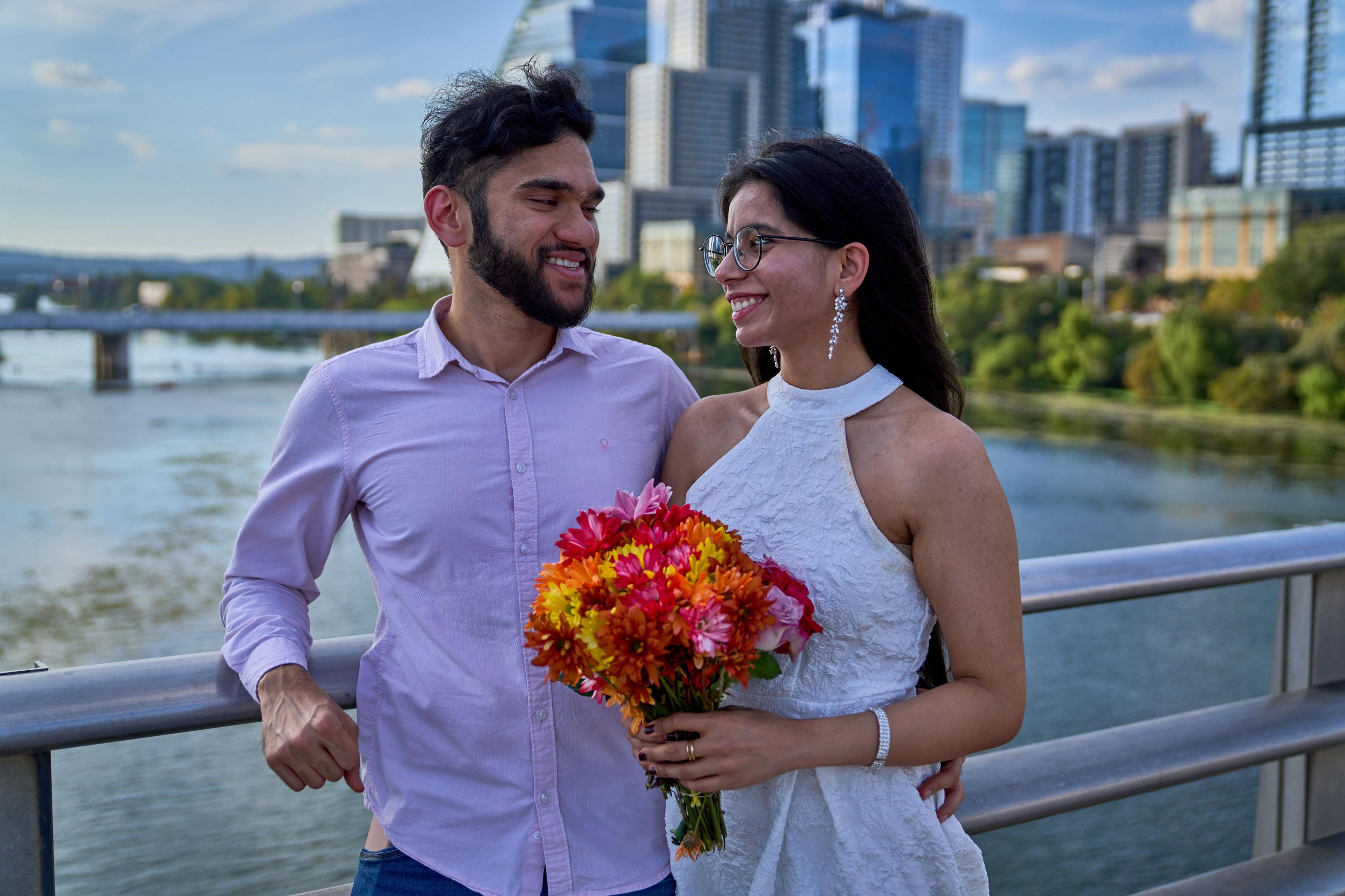 Bride holding a bright market bouquet beside her groom in a lilac shirt — Congress Avenue photography, Austin A bride holding a bright market bouquet beside her groom in a lilac shirt.