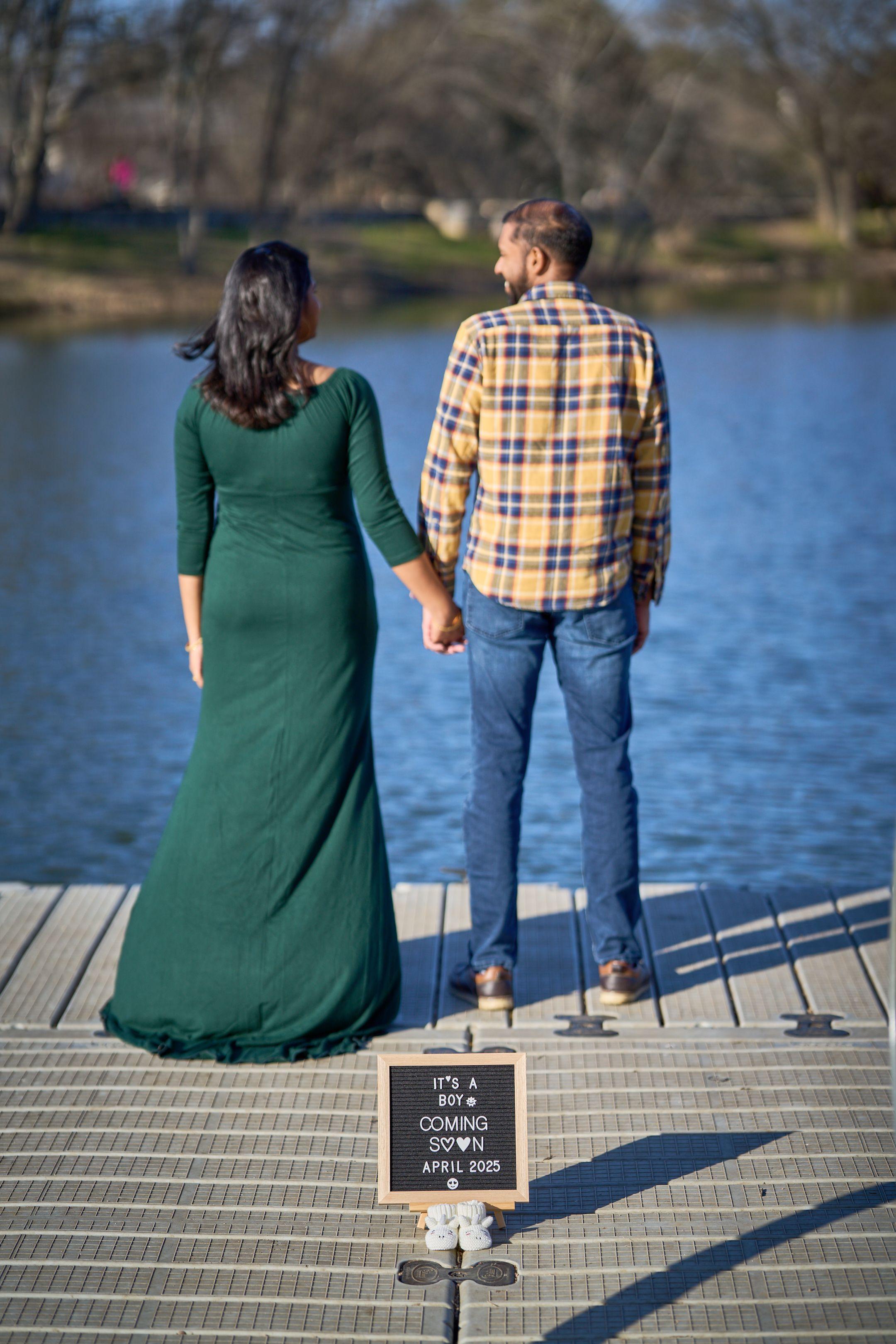 Couple standing with their backs to the camera on the Mills Pond pier — Mills Pond photography, Austin A couple standing with their backs to the camera on the Mills Pond pier, an announcement sign propped on the boards behind them