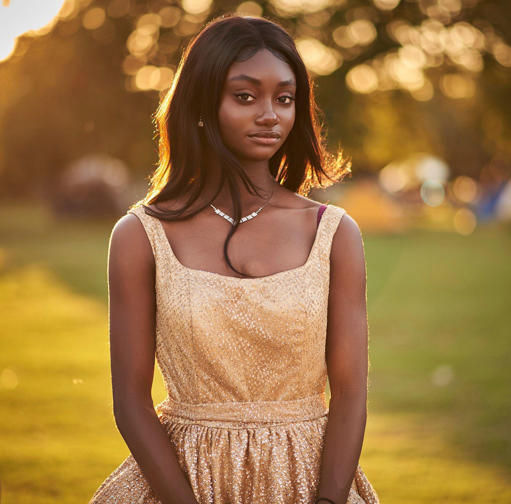 Woman in a gold dress standing in warm backlit bokeh at golden hour — Photo retouching, Austin A woman in a gold dress standing in warm backlit bokeh at golden hour.