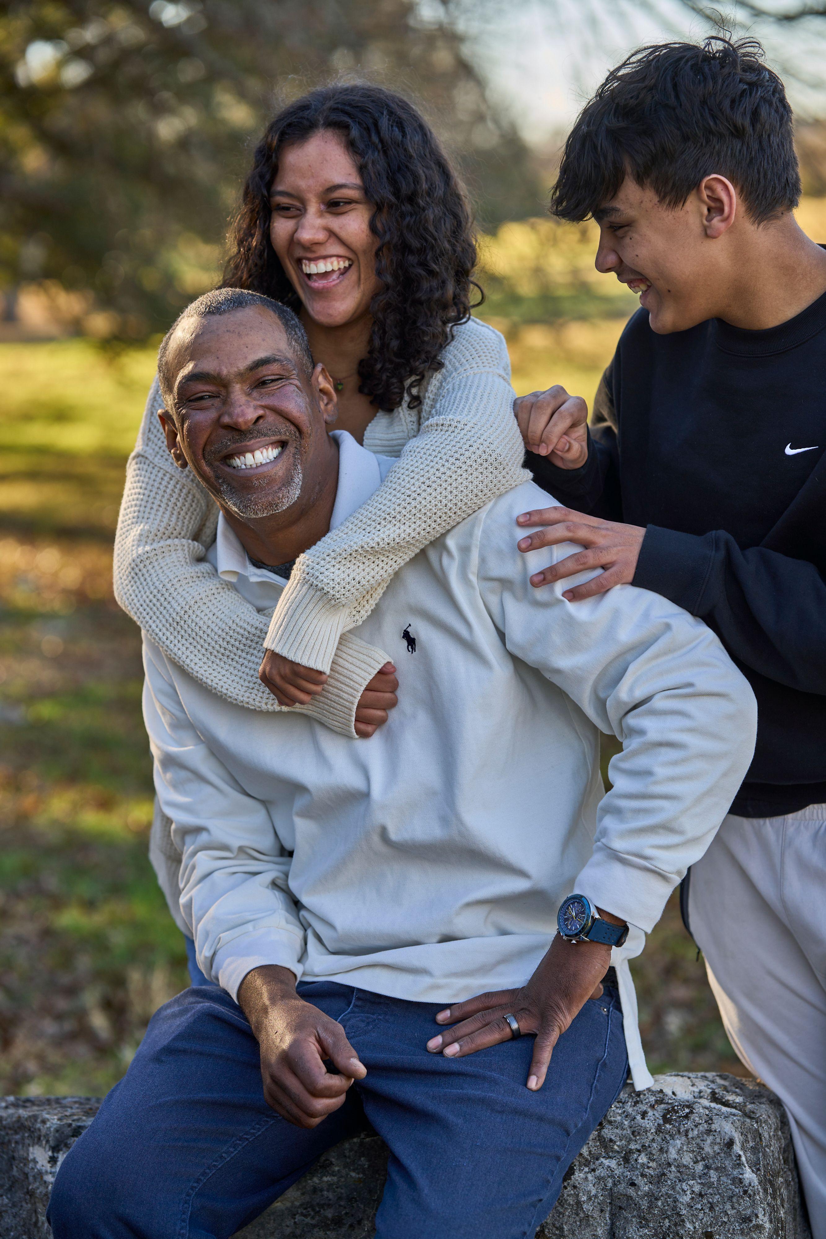 Father giving a piggyback on the meadow at Olson Meadows Park while the family laughs — Olson Meadows Park photography, Austin A father giving a piggyback on the meadow at Olson Meadows Park while the family laughs