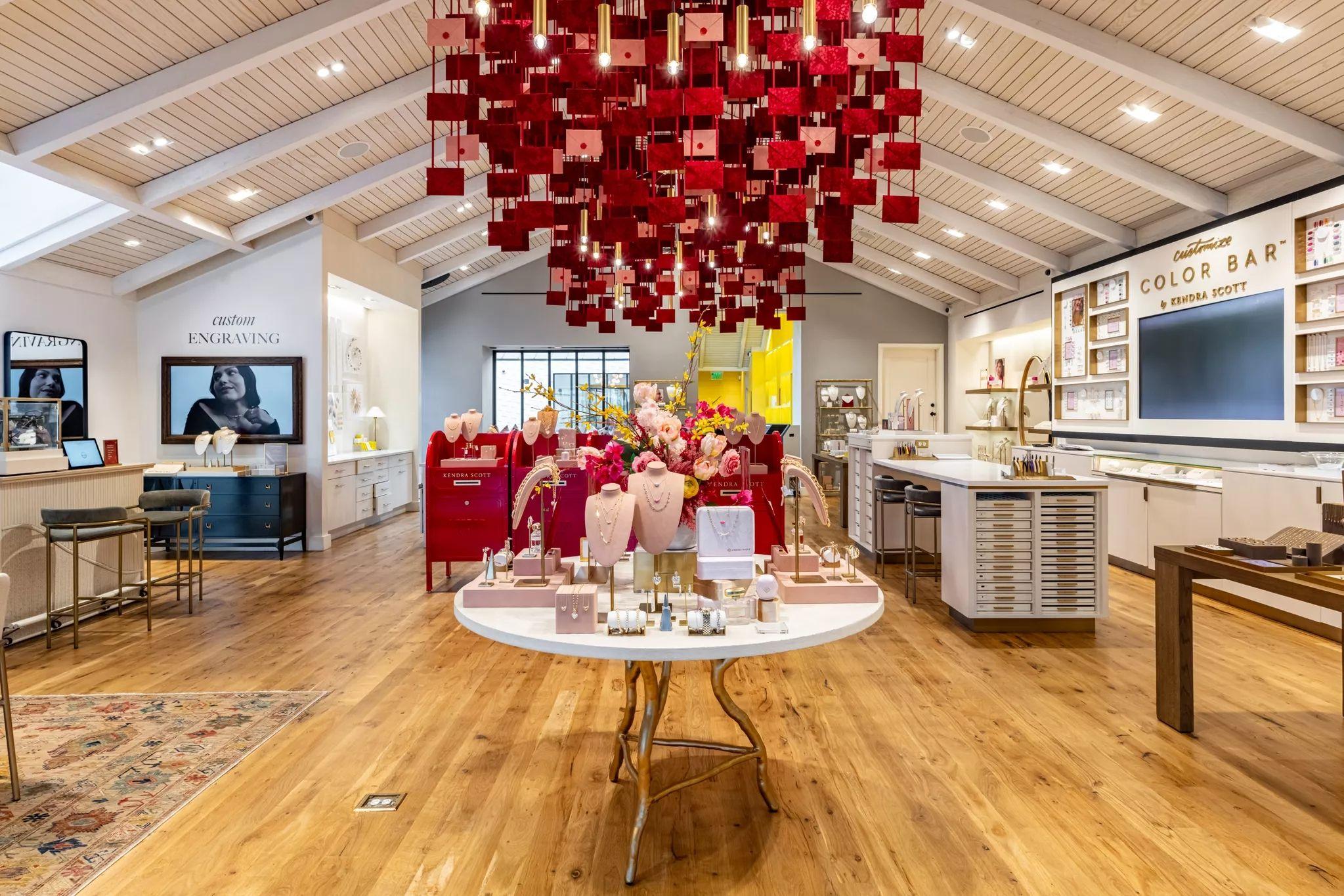 Kendra Scott store under a ceiling of hanging red envelopes, red mailboxes — Brand Collaborations photography, Austin A Kendra Scott store under a ceiling of hanging red envelopes, red mailboxes and a flowered display table below.