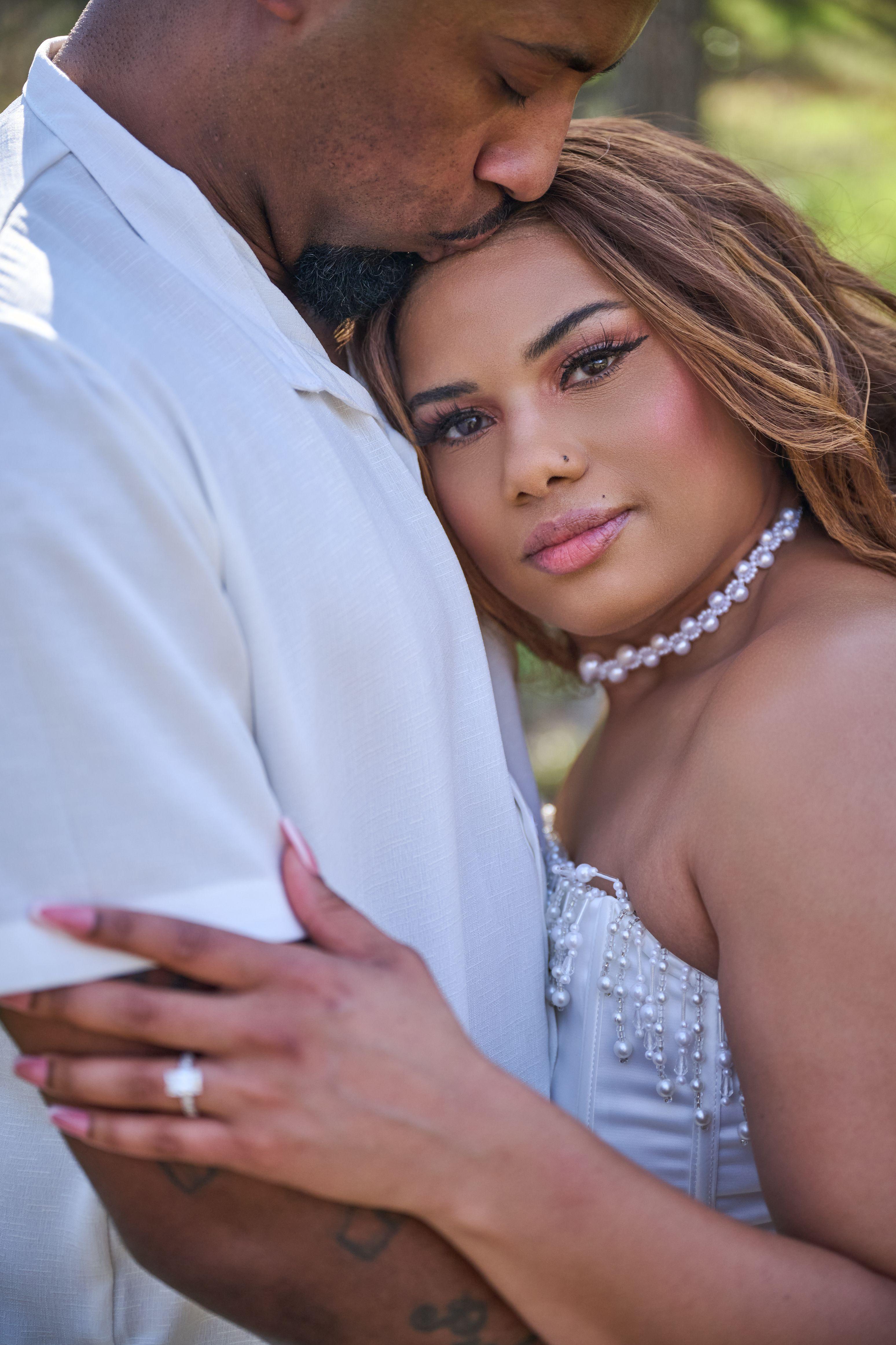 Couple standing close in Pease Park, the woman in a white dress and pearl choker looking — Pease Park photography, Austin A couple standing close in Pease Park, the woman in a white dress and pearl choker looking at the camera