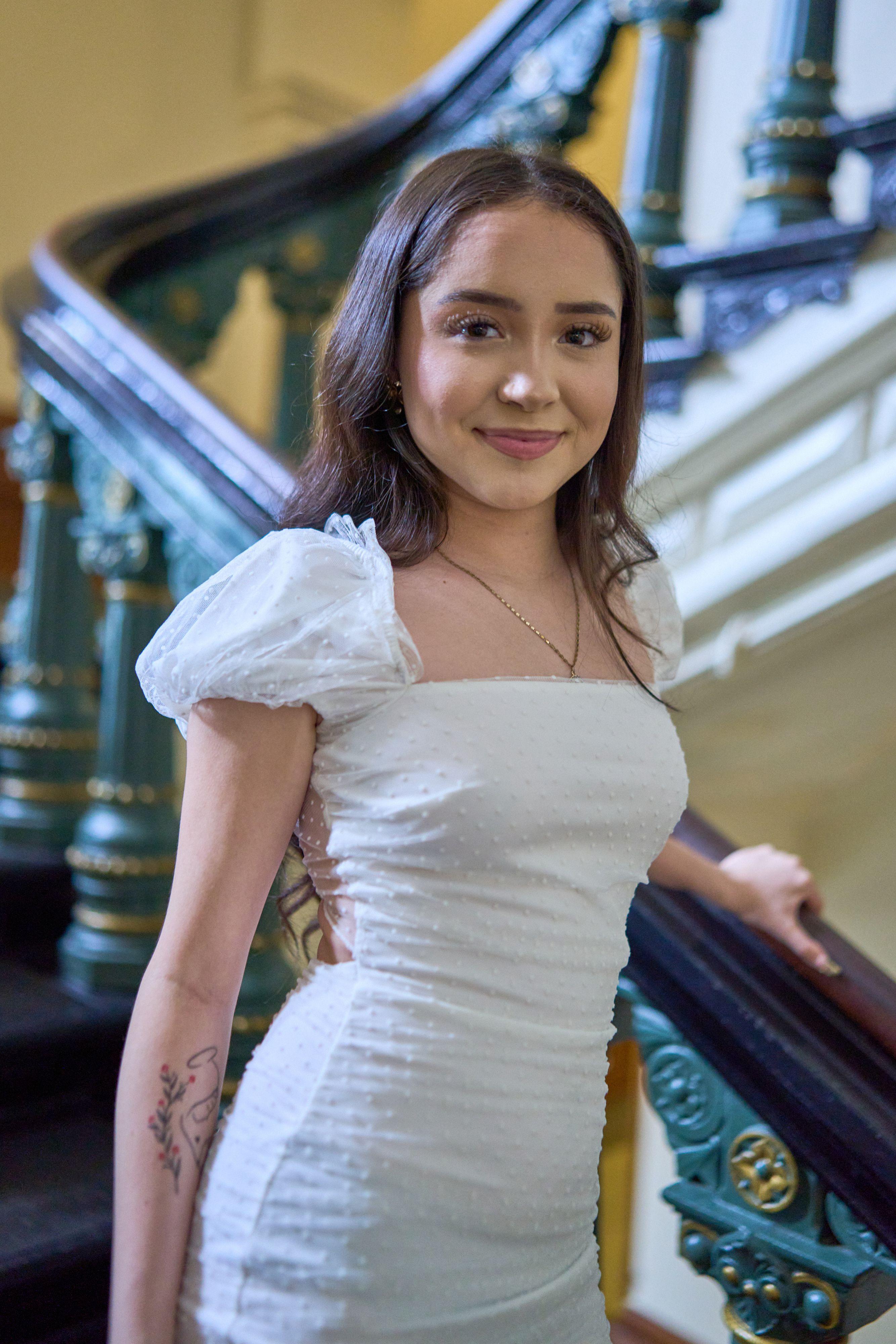 Young woman in a white dress on the Capitol's brass and marble staircase — Texas State Capitol photography, Austin A young woman in a white dress on the Capitol's brass and marble staircase.