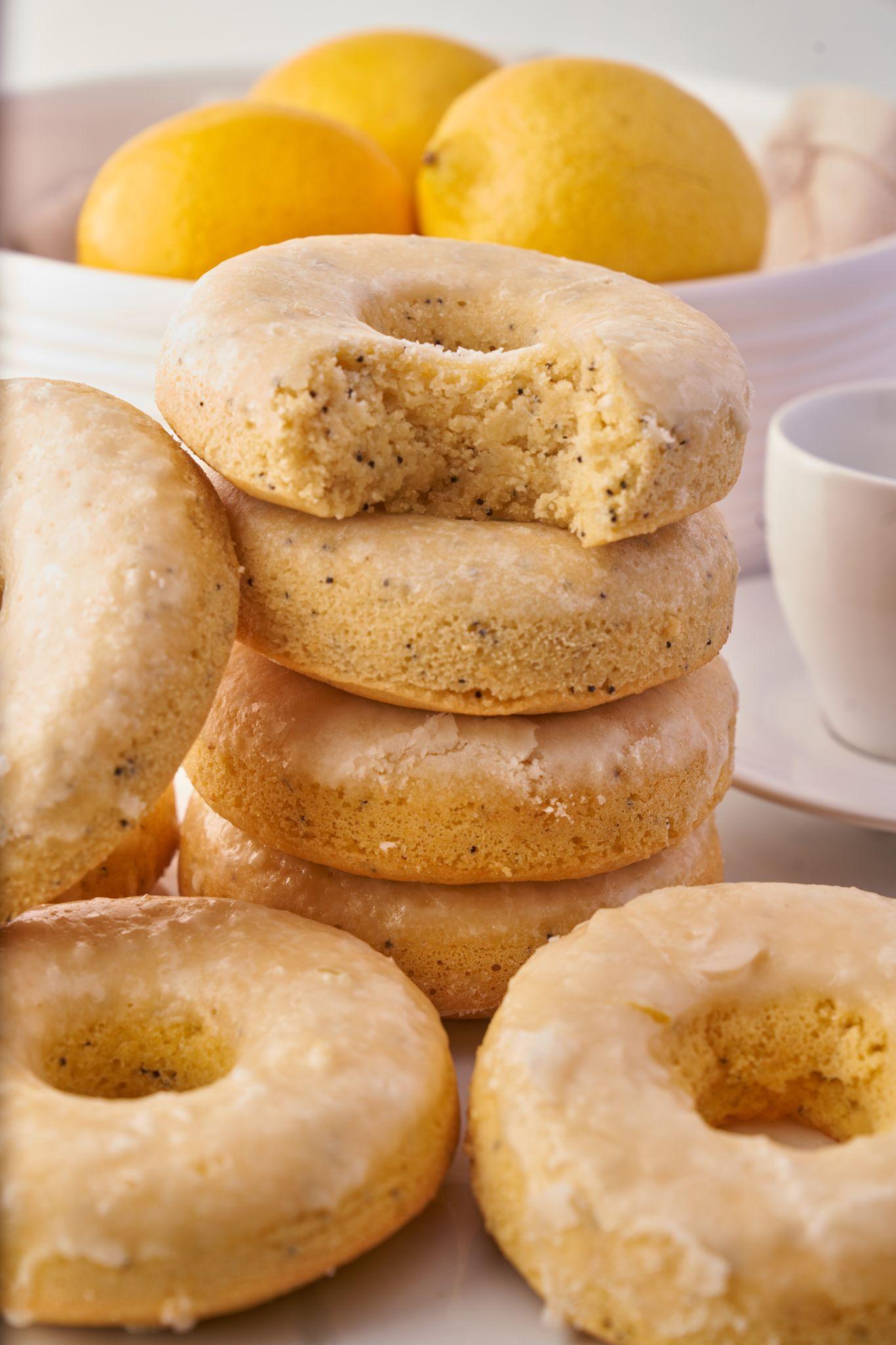 Stack of glazed lemon poppyseed doughnuts with whole lemons and a cup behind them — E-commerce & apparel photography, Austin Stack of glazed lemon poppyseed doughnuts with whole lemons and a cup behind them