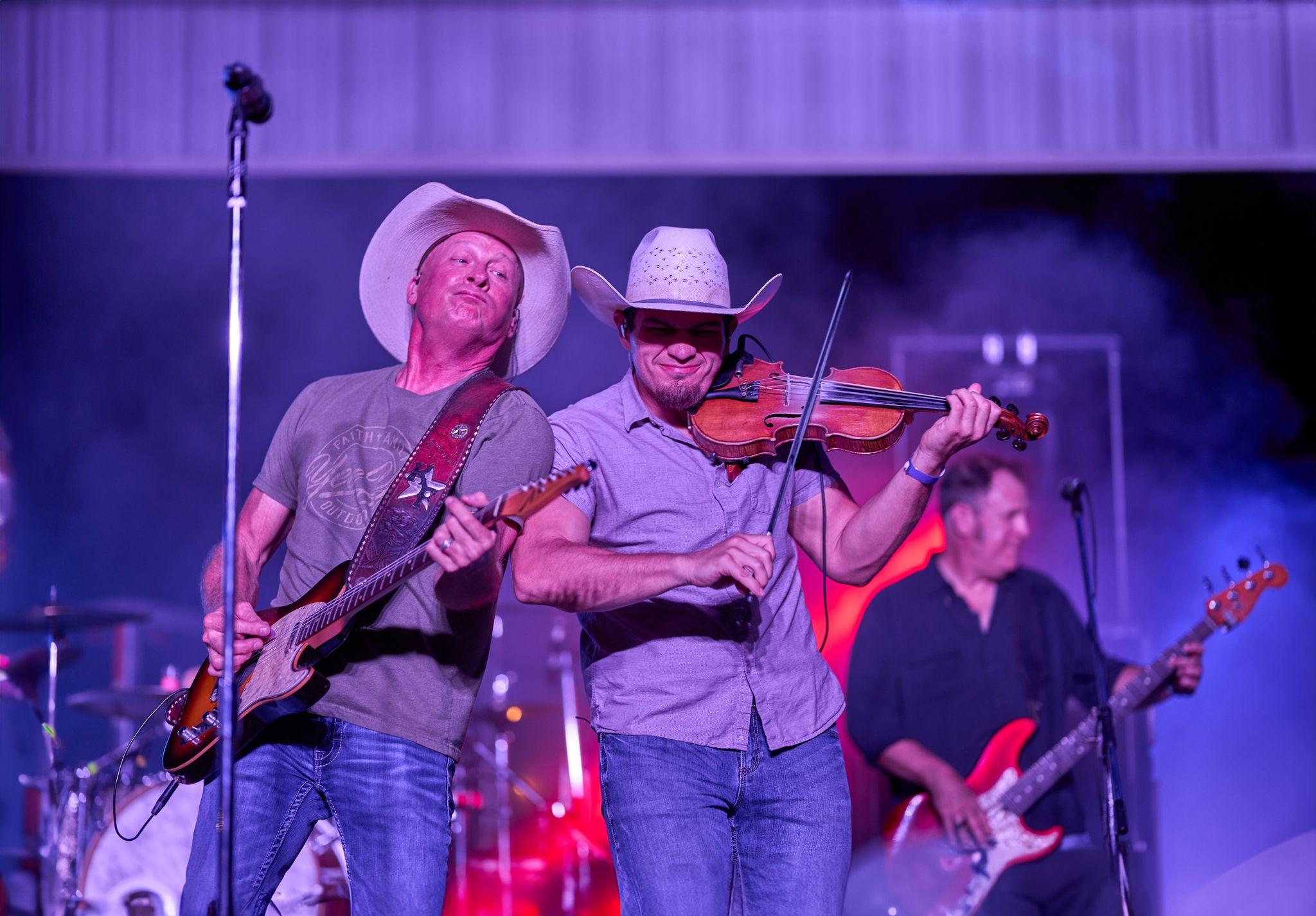 Country band with a fiddle player and guitarist performing in cowboy hats — Live music photography, Austin A country band with a fiddle player and guitarist performing in cowboy hats.