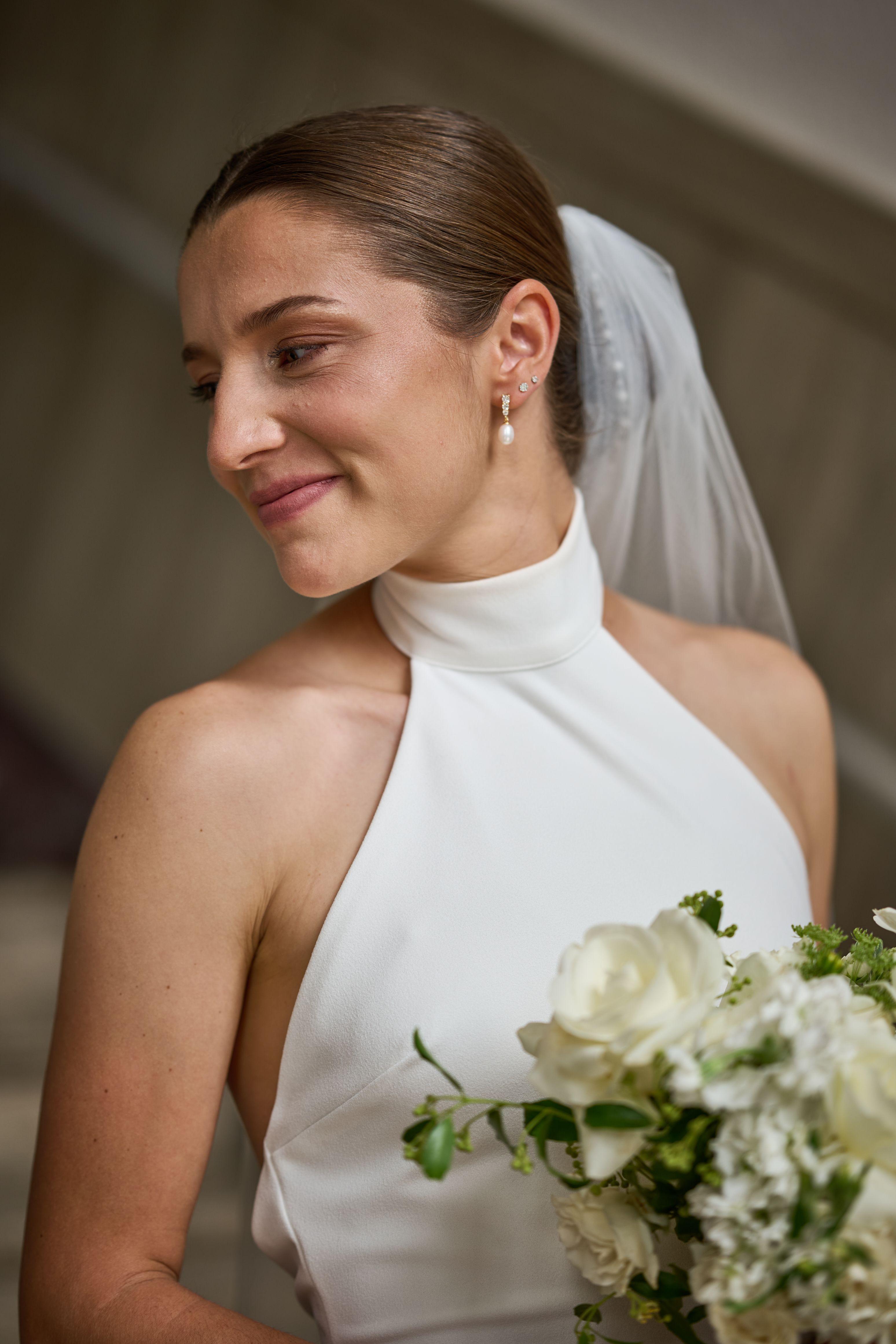 Bride in a white halter gown and veil glancing away, softly lit — Weddings photography, Austin A bride in a white halter gown and veil glancing away, softly lit.