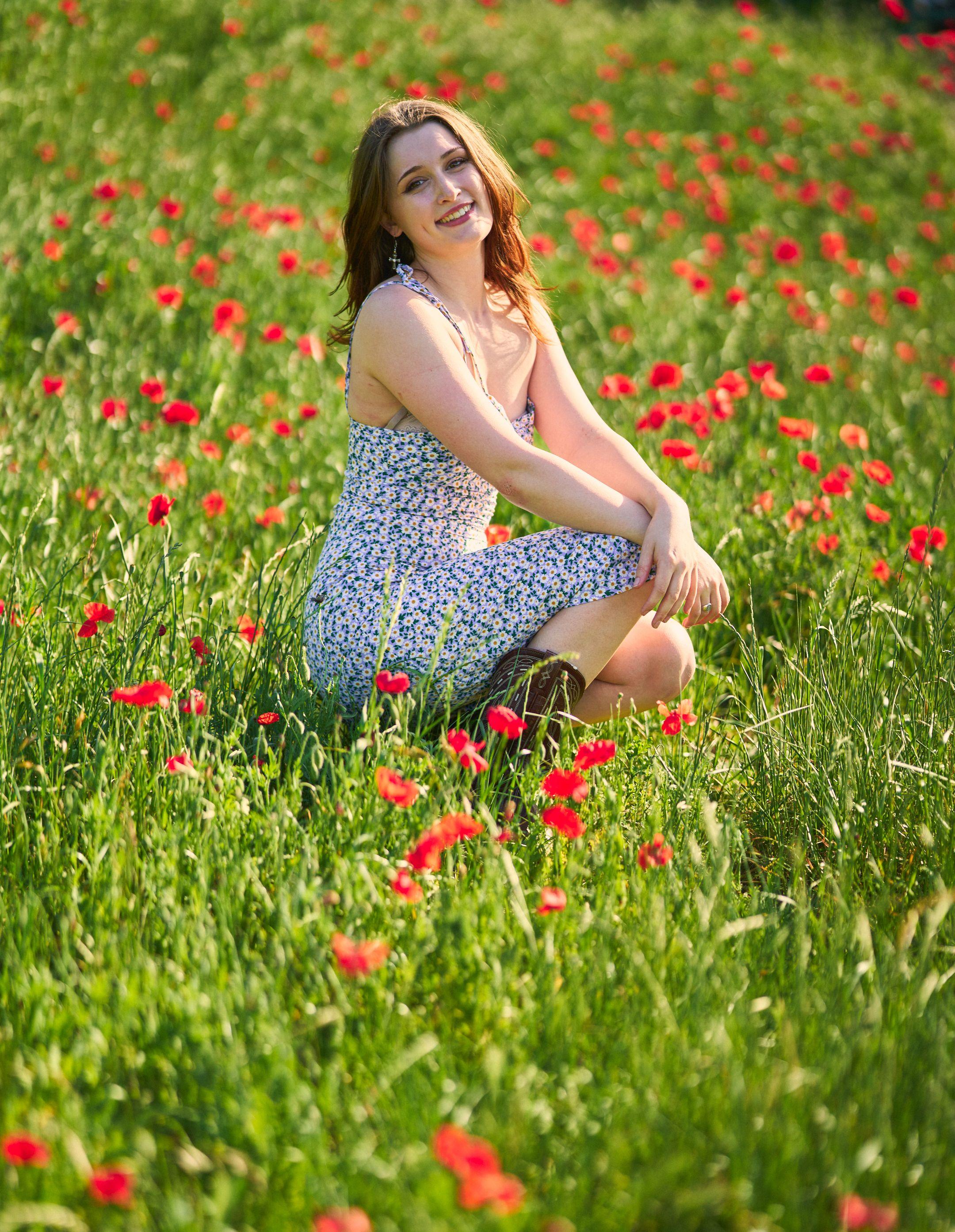 Woman in a blue floral dress sitting in a sunlit field of red poppies — Seasonal Wildflower Season in Texas photography, Austin Seasonal Wildflower Season in Texas