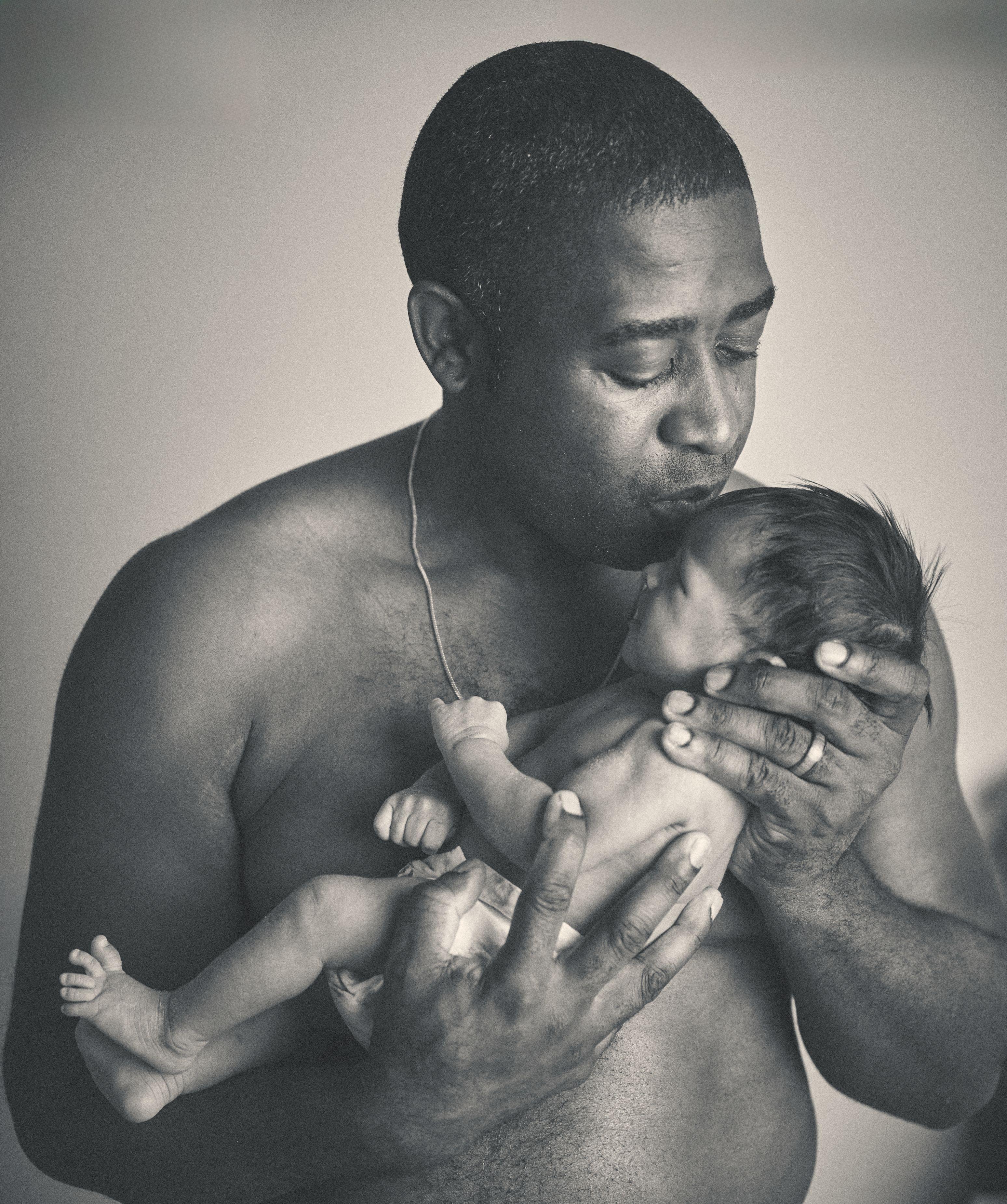 Black and white photograph of a father kissing his newborn baby — Film & vintage photography, Austin A black and white photograph of a father kissing his newborn baby.