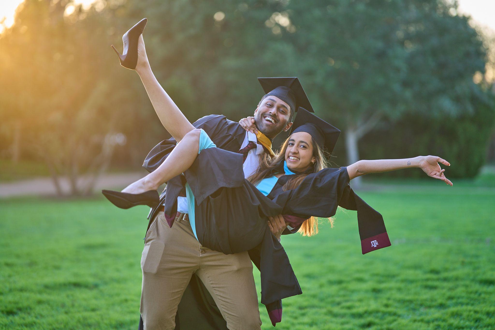 Two graduates in caps and gowns on the lawn at Mueller Lake Park, one carrying the other — Mueller Lake Park & Butterfly Garden photography, Austin Two graduates in caps and gowns on the lawn at Mueller Lake Park, one carrying the other with arms flung out