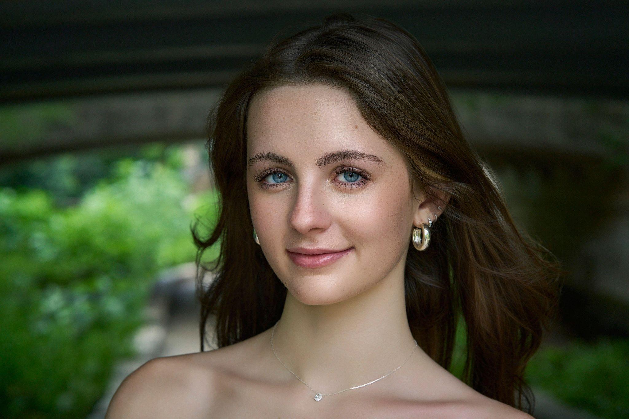 Close beauty portrait of a woman with blue eyes and a bare shoulder against a dark background — Photo retouching, Austin A close beauty portrait of a woman with blue eyes and a bare shoulder against a dark background.