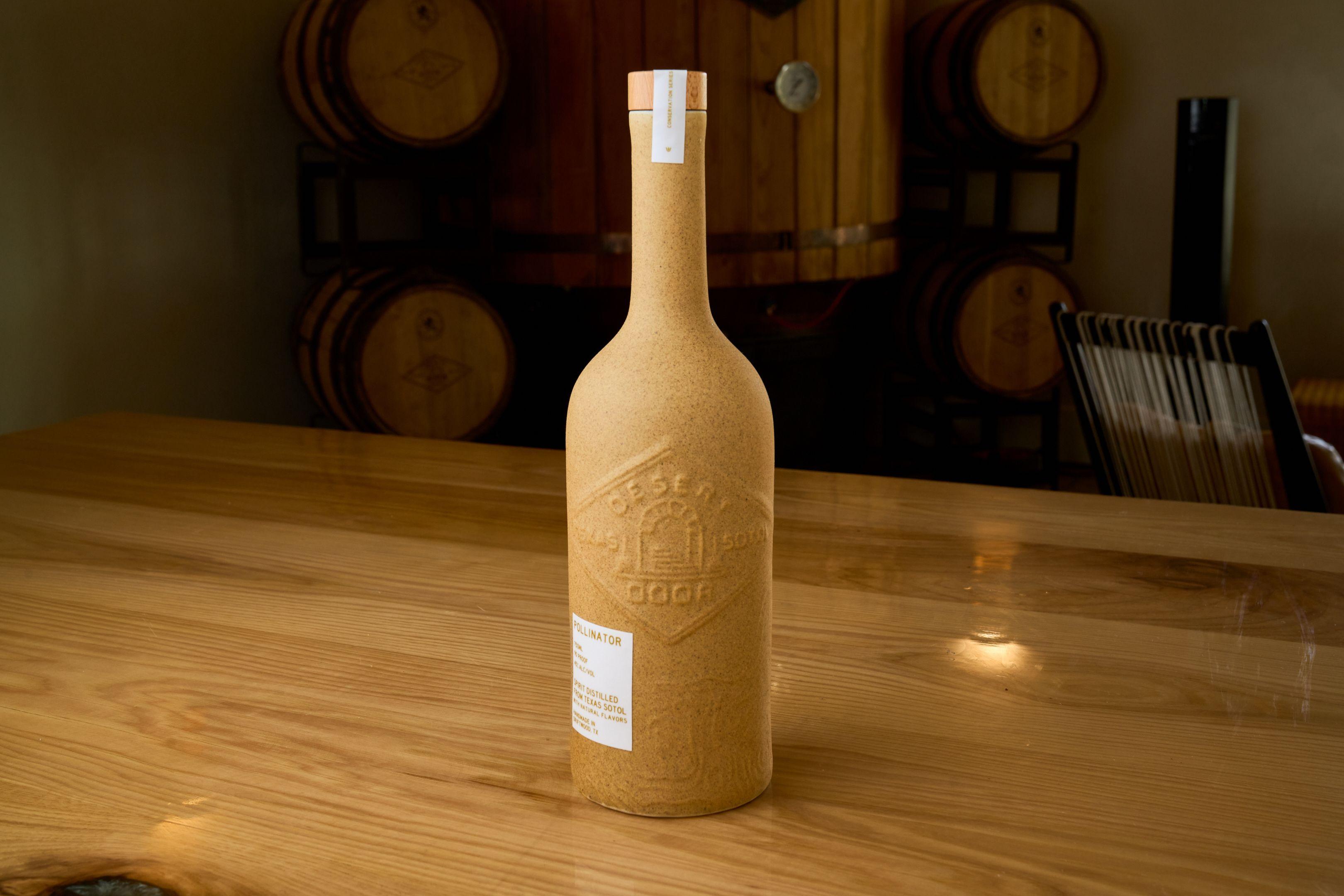 Wax-sealed bottle standing on a table in a barrel room — Product photography, Austin A wax-sealed bottle standing on a table in a barrel room.