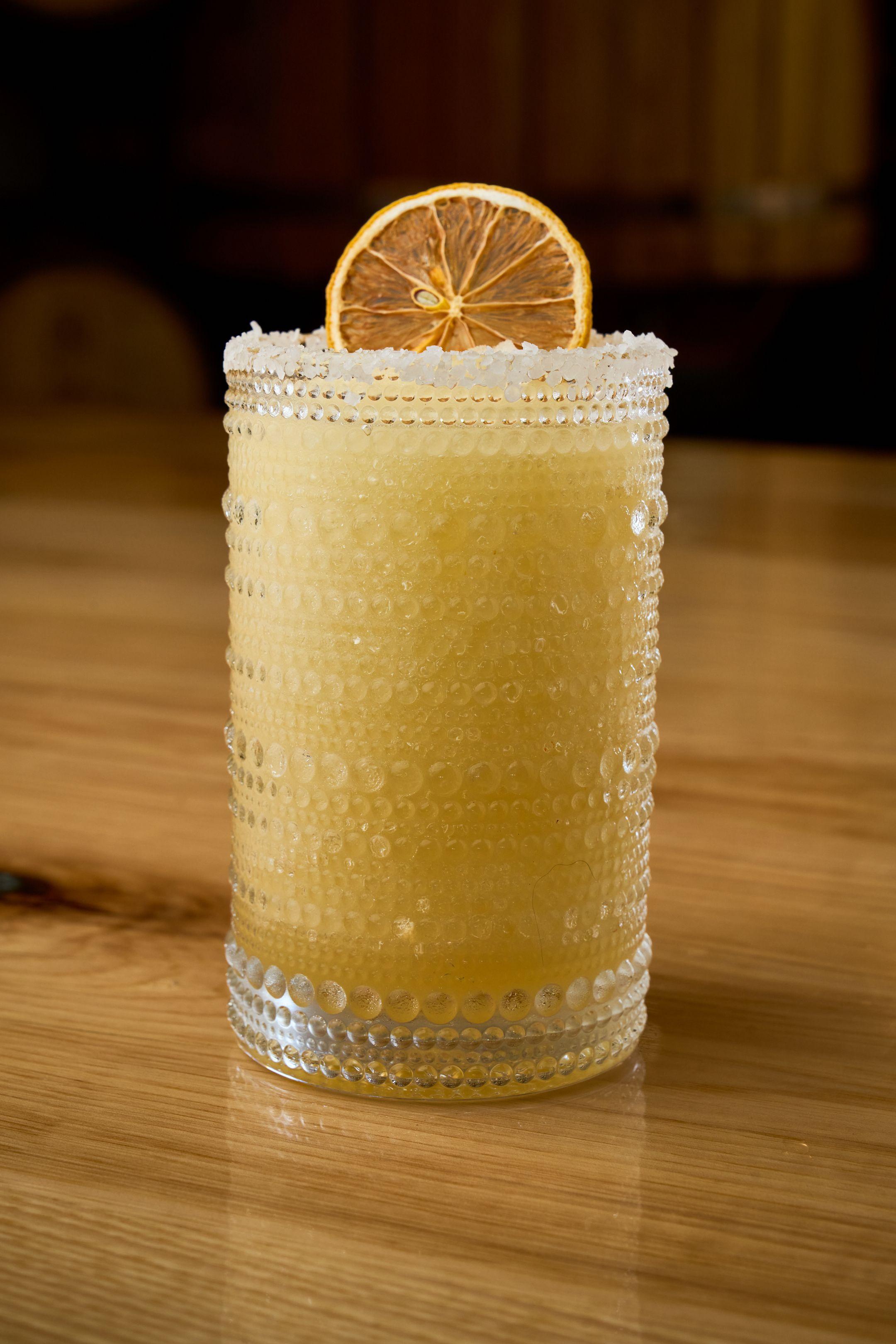 Frozen cocktail in a textured glass topped with a dried orange wheel — Food & restaurant photography, Austin A frozen cocktail in a textured glass topped with a dried orange wheel.