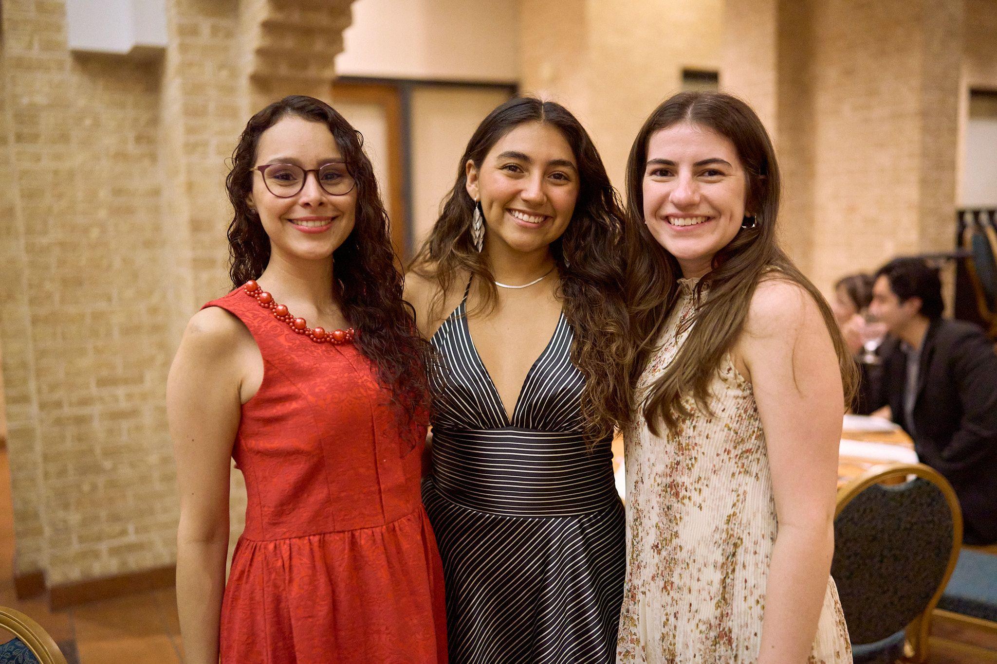 Three students in formal dresses posed together at a campus banquet — UT Austin photography, Austin Three students in formal dresses posed together at a campus banquet.
