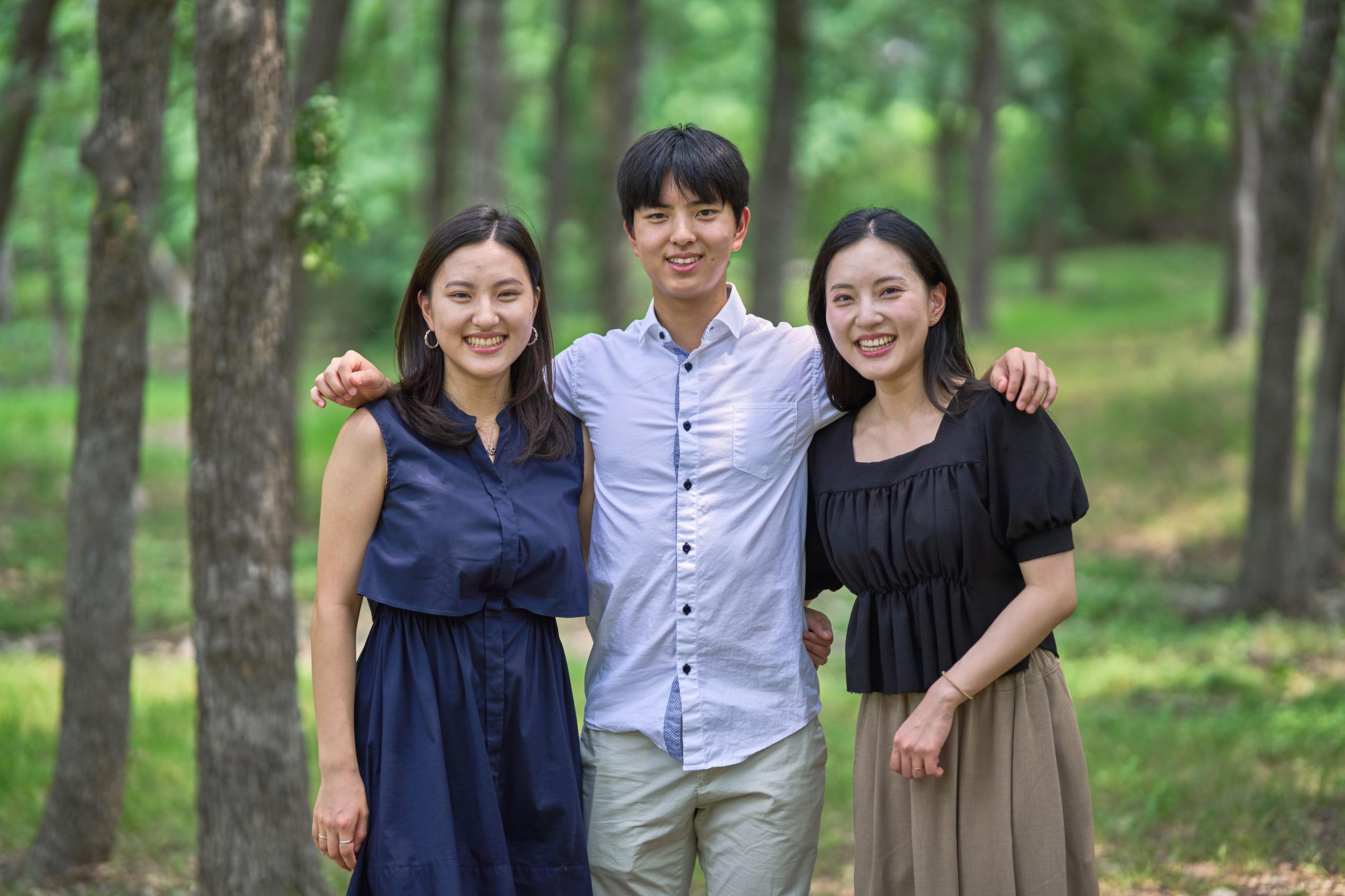 Three siblings standing arm in arm among the pines at Olson Meadows Park — Olson Meadows Park photography, Austin Three siblings standing arm in arm among the pines at Olson Meadows Park