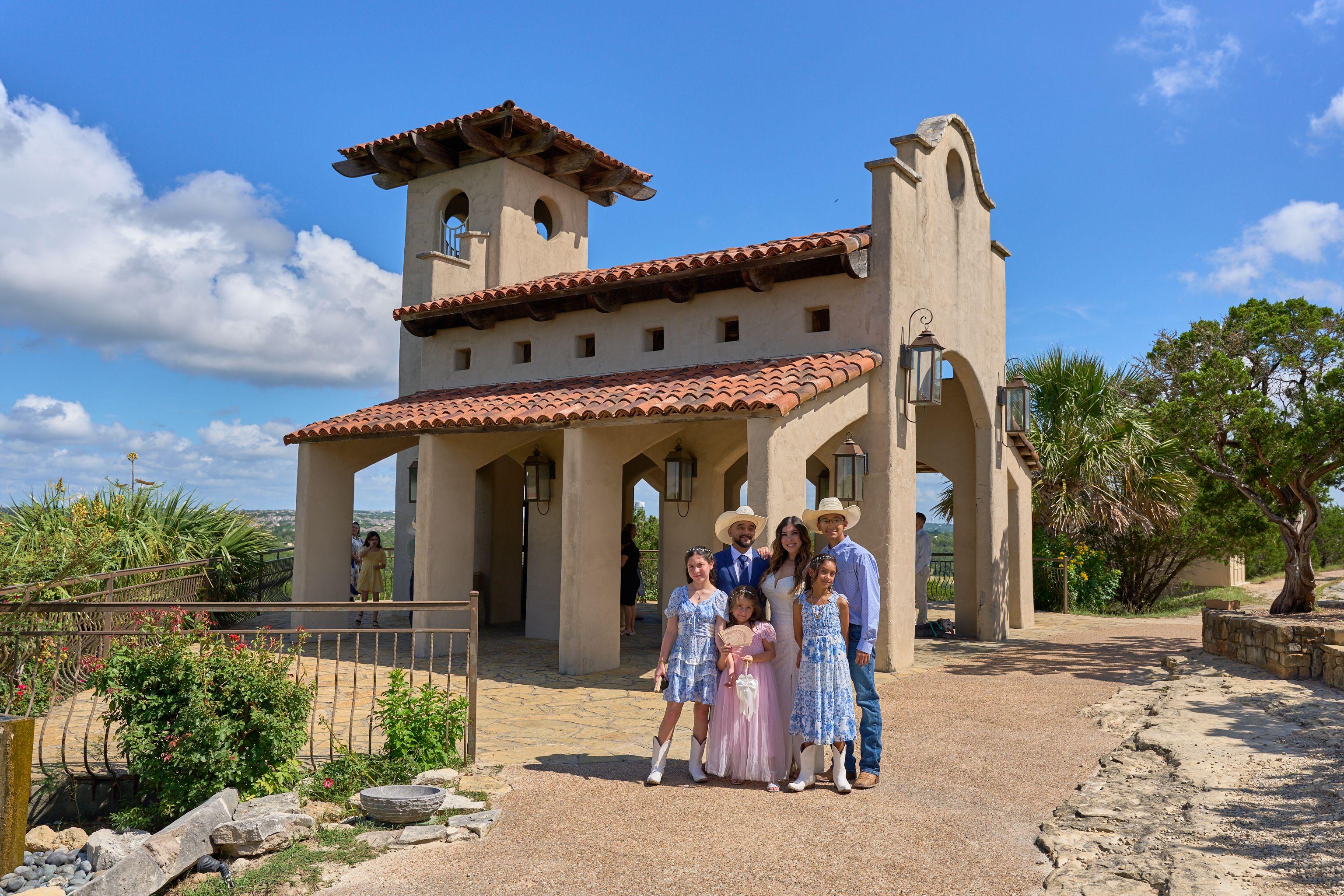 Family in blue and pink standing on the path outside Chapel Dulcinea in the sun — Chapel Dulcinea photography, Austin A family in blue and pink standing on the path outside Chapel Dulcinea in the sun