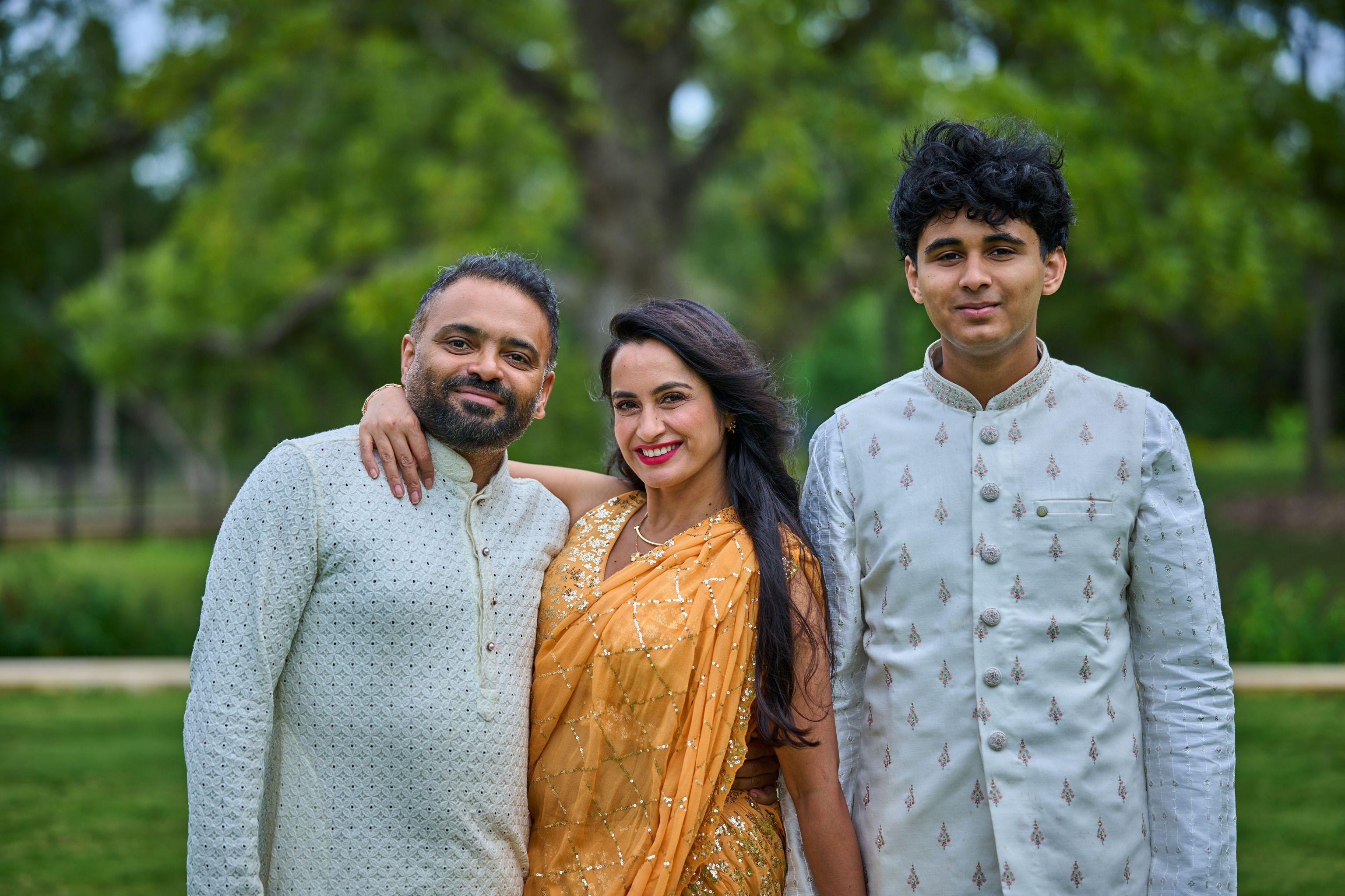 Family in gold sari and embroidered kurtas standing together in a garden — Cedar Park Public Library photography, Austin A family in gold sari and embroidered kurtas standing together in a garden.