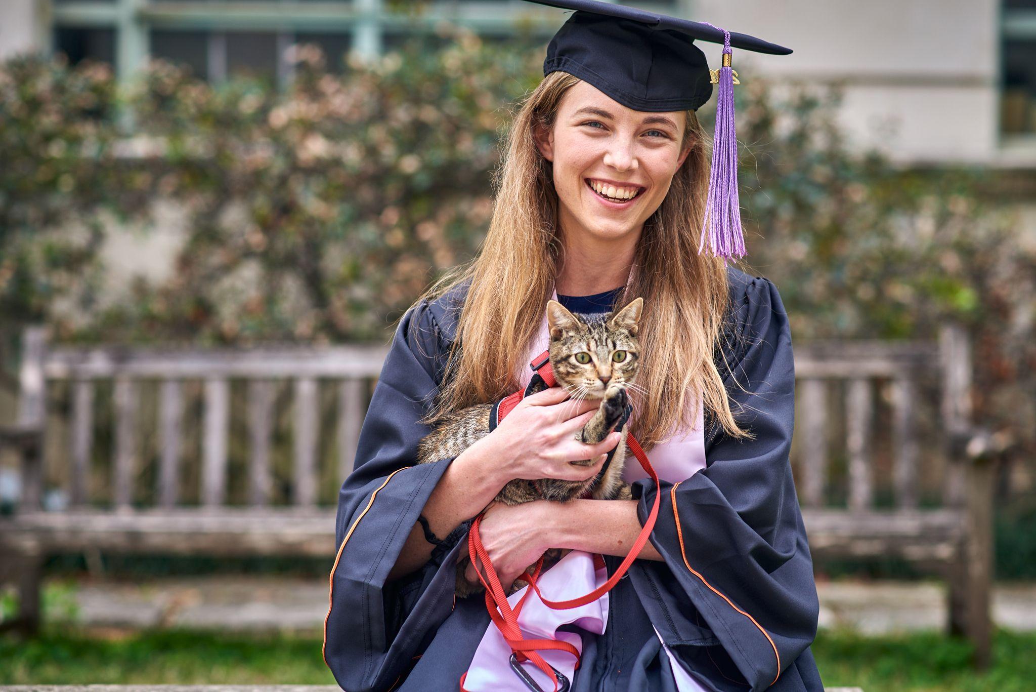 Graduate in cap and gown holding a tabby cat in her arms — Graduation & Prom photography, Austin A graduate in cap and gown holding a tabby cat in her arms.