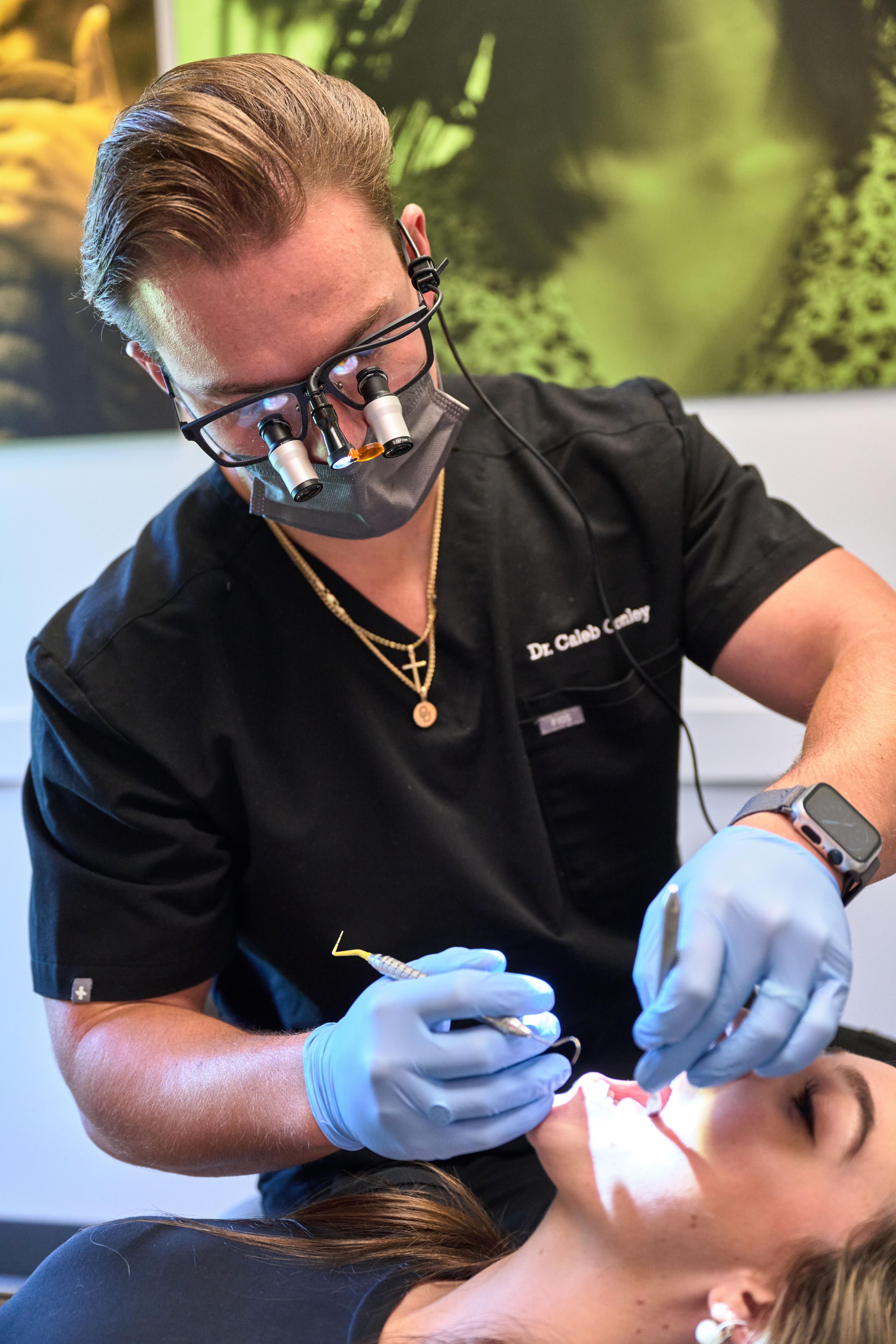 Dentist wearing magnifying loupes and gloves working on a patient in the chair — Medical team photography, Austin Dentist wearing magnifying loupes and gloves working on a patient in the chair