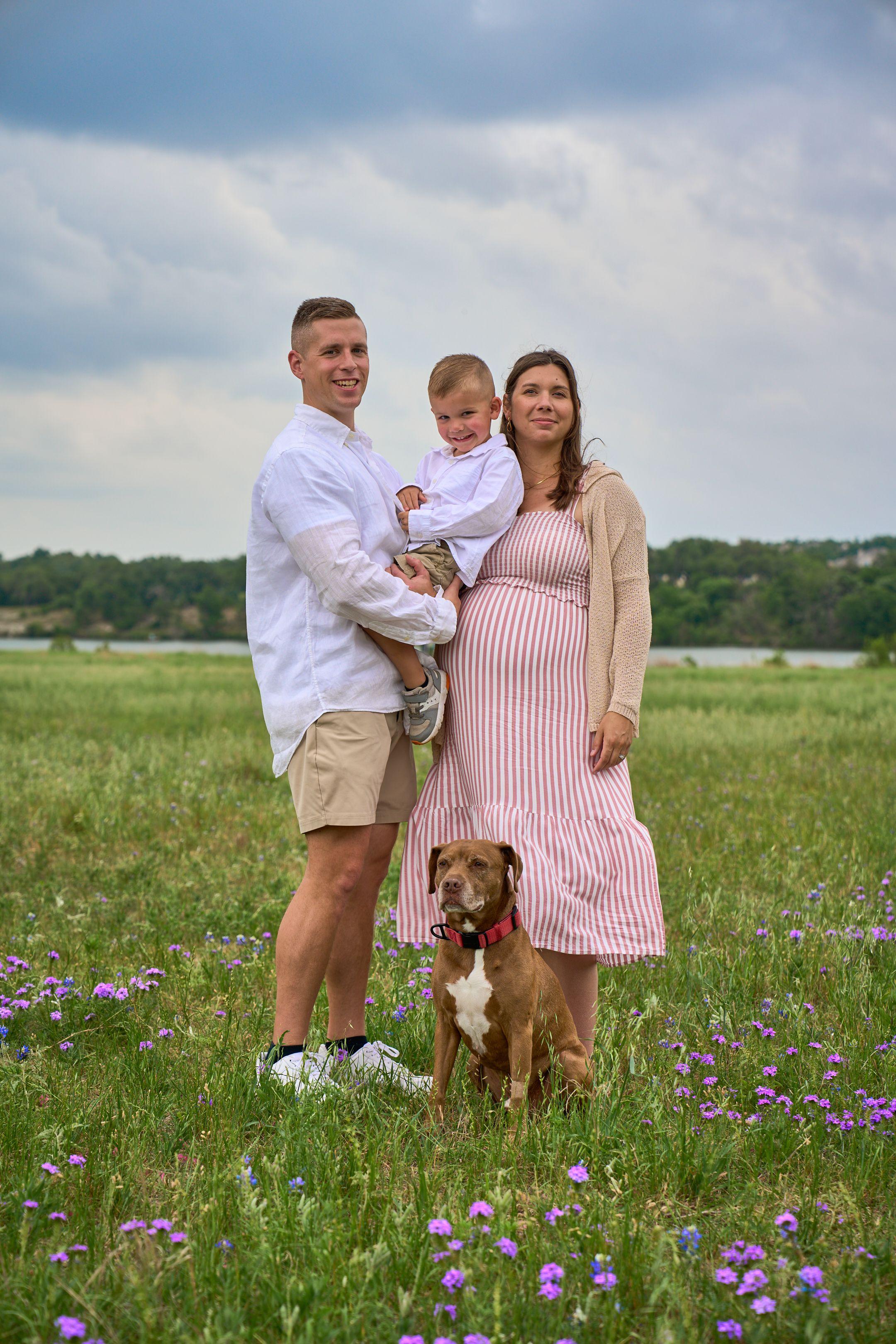 Family standing with their dog in a wide meadow of wildflowers — Brushy Creek Lake Park photography, Austin A family standing with their dog in a wide meadow of wildflowers.